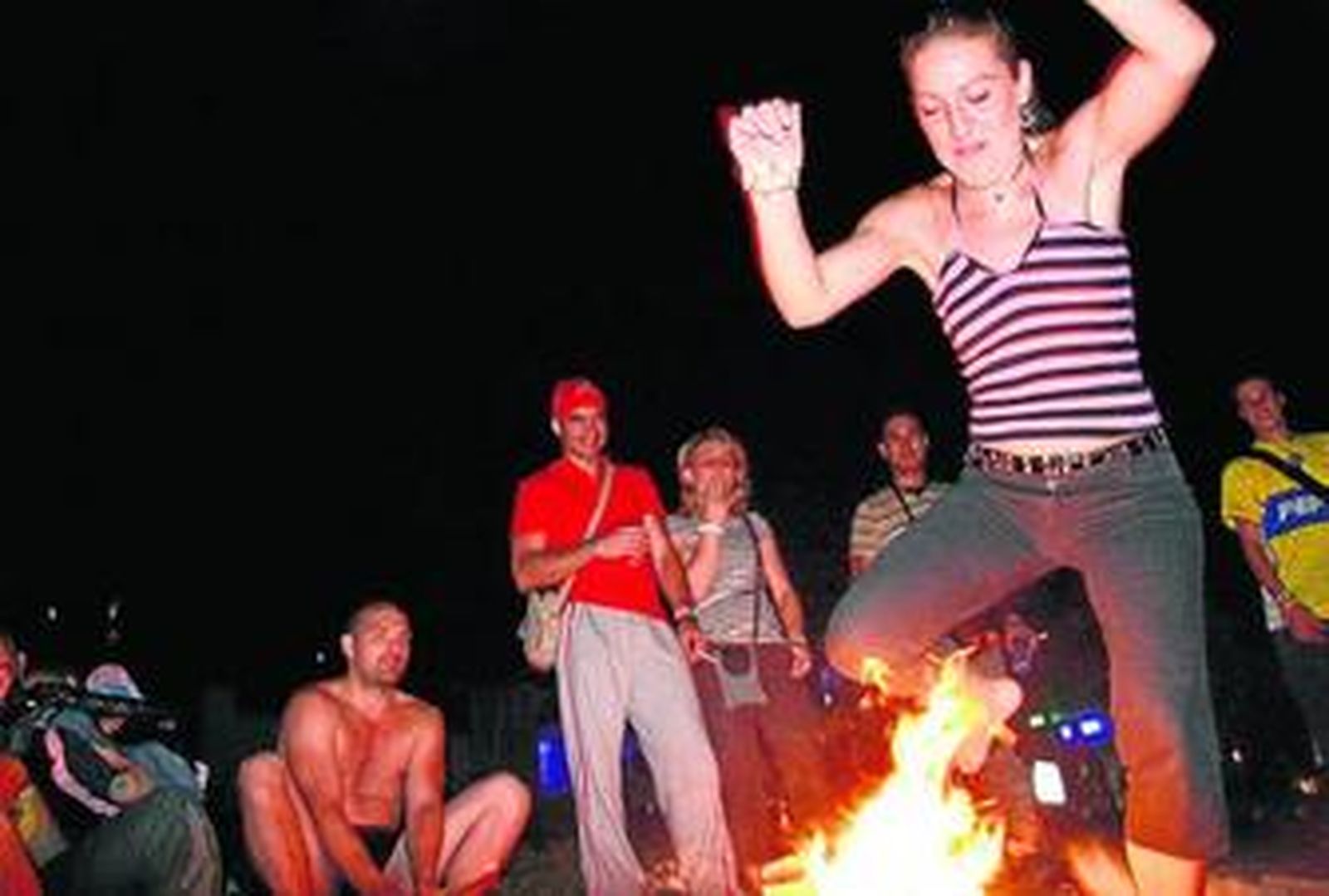 Una onubense, saltando sobre las llamas de una hoguera en Punta Umbría el año pasado.