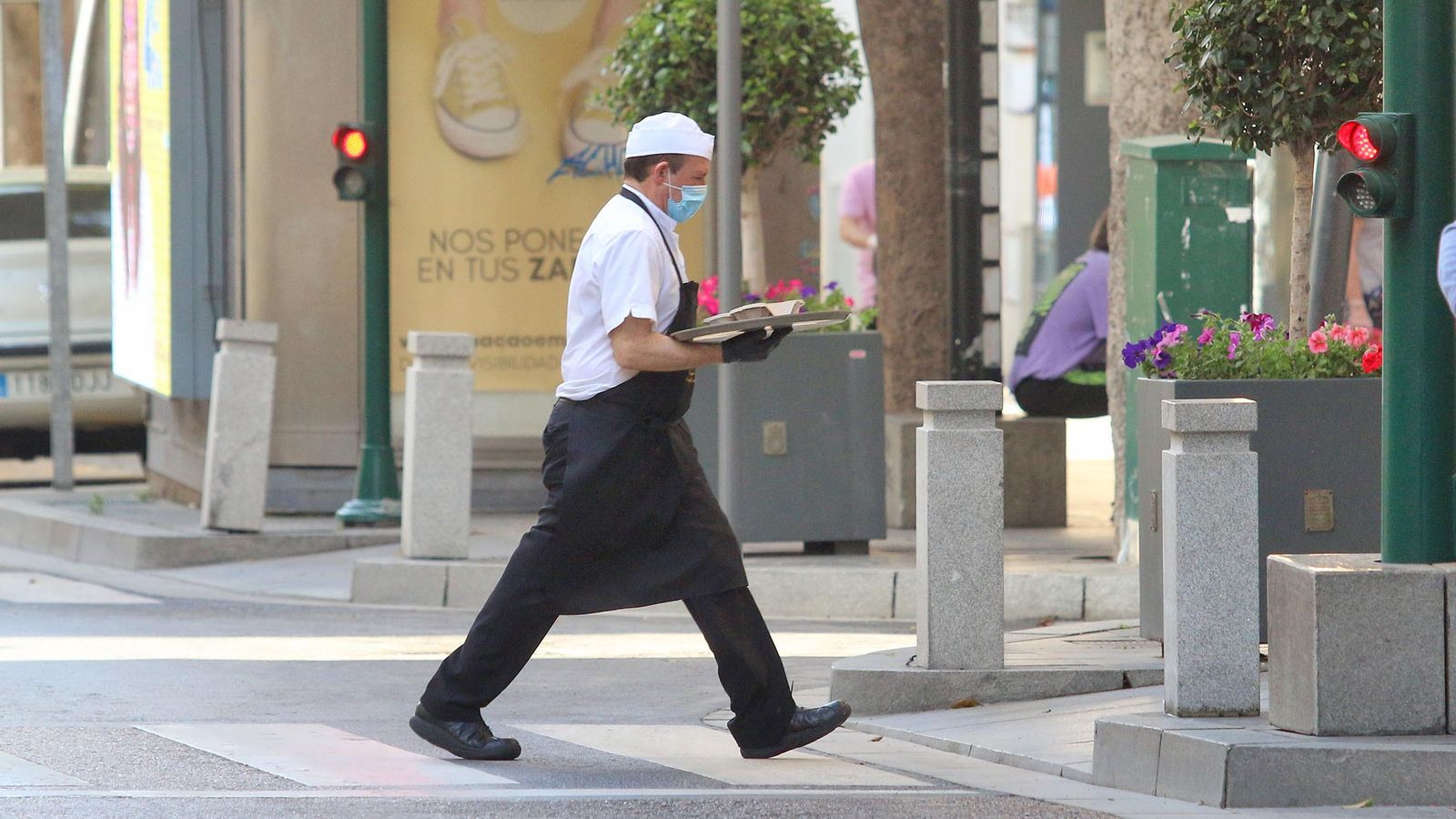 Un camarero de un negocio del centro repartiendo, este lunes, comida a domicilio.