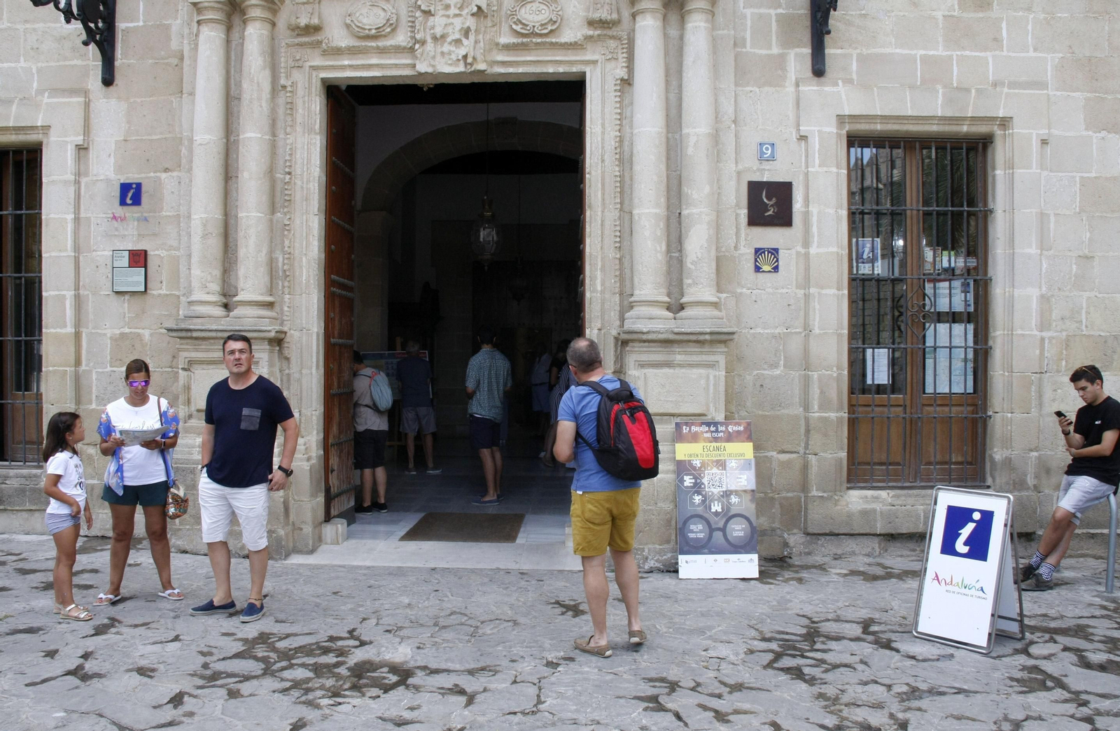 Visitantes llegados a la ciudad, en la puerta de la oficina de Turismo de El Puerto.