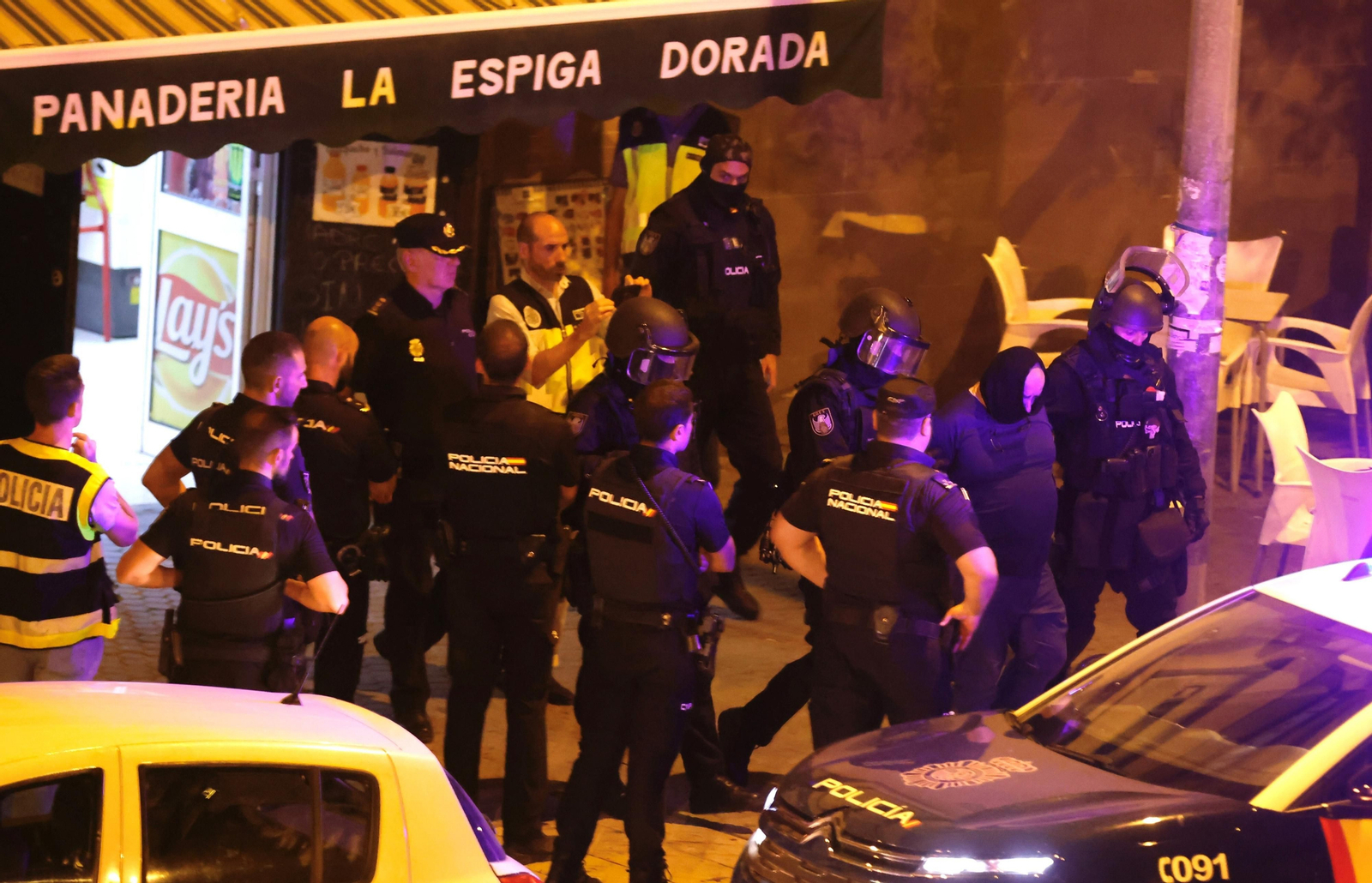 La Policía saca al detenido de la panadería.