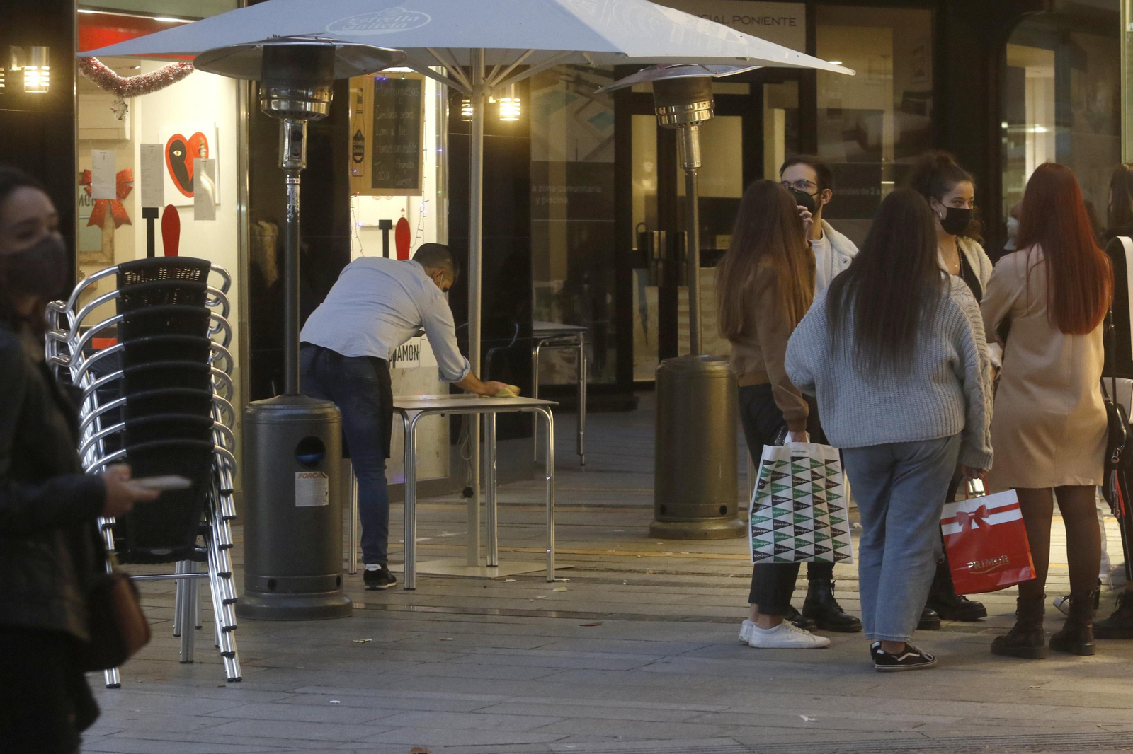Un camarero limpia la mesa de una terraza. Un camarero limpia la mesa de una terraza.