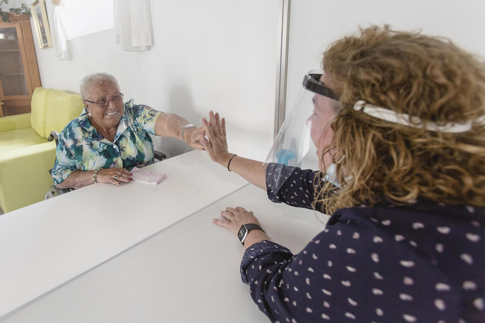 Una residente saluda a un familiar tras un cristal después de los meses de confinamiento,  en la residencia gaditana de Fragela.