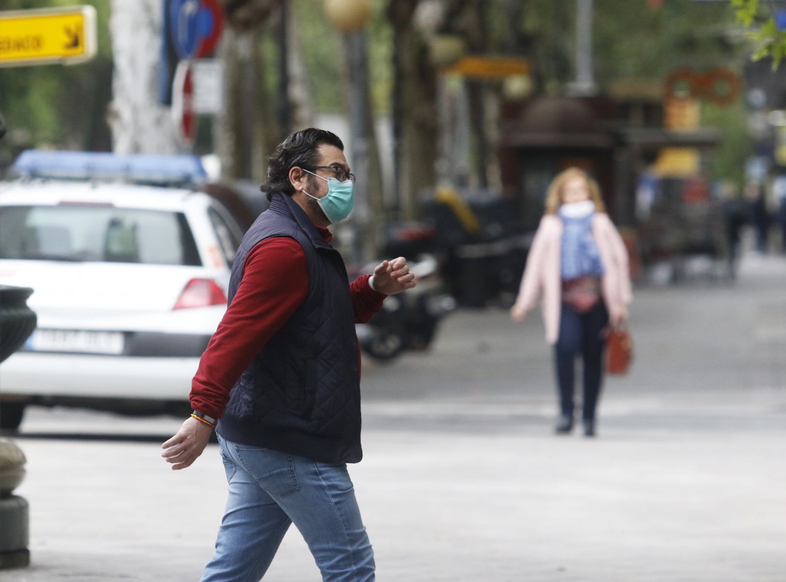 Un hombre camina con una mascarilla.