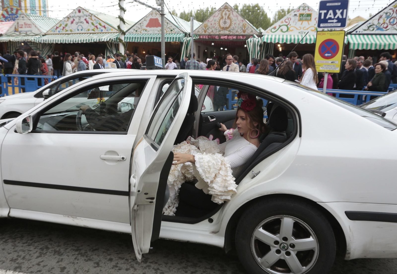 Una joven llega a la Feria en taxi.
