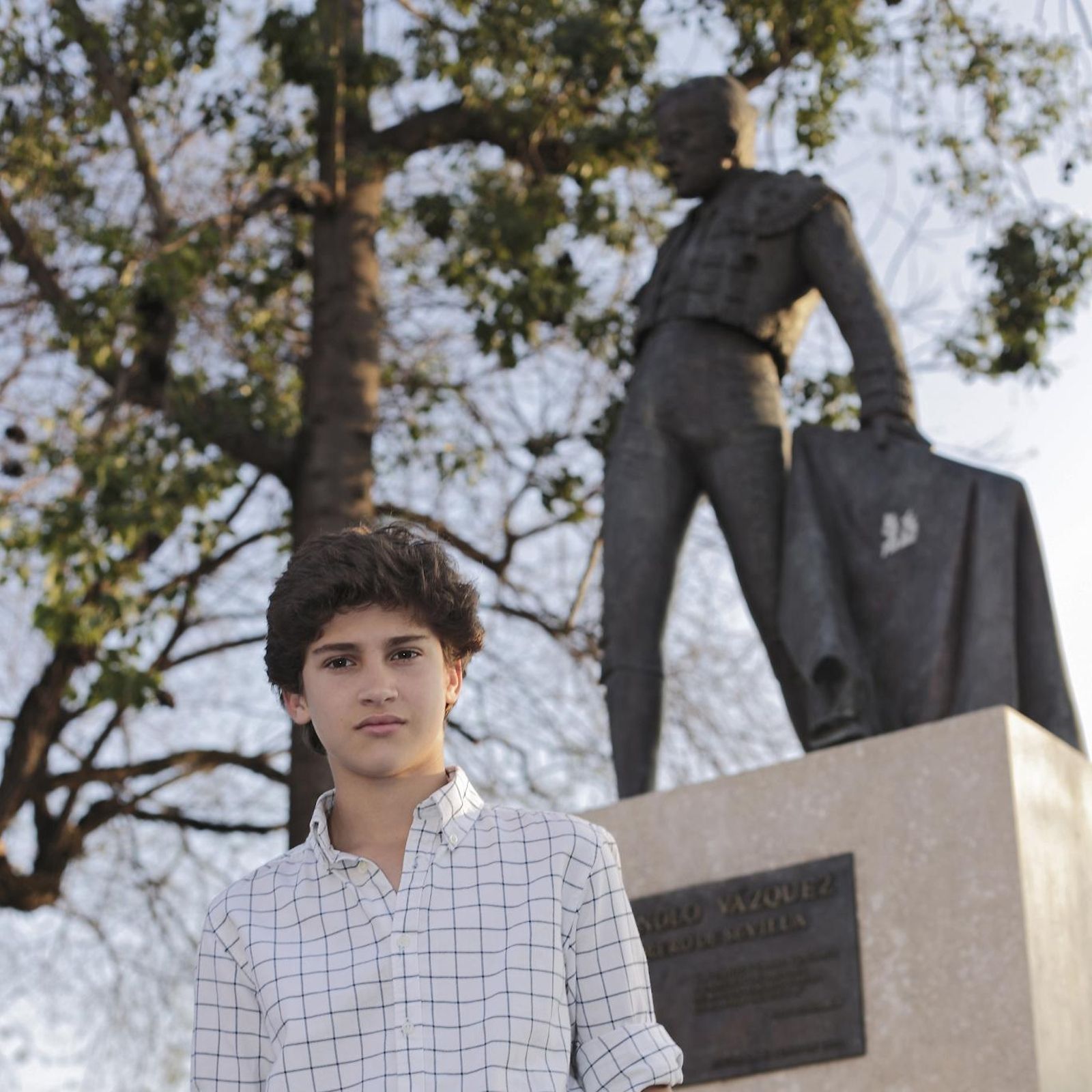 El último Manolo Vázquez, casi un niño aún, delante del monumento de su abuelo en el paseo de Colón.