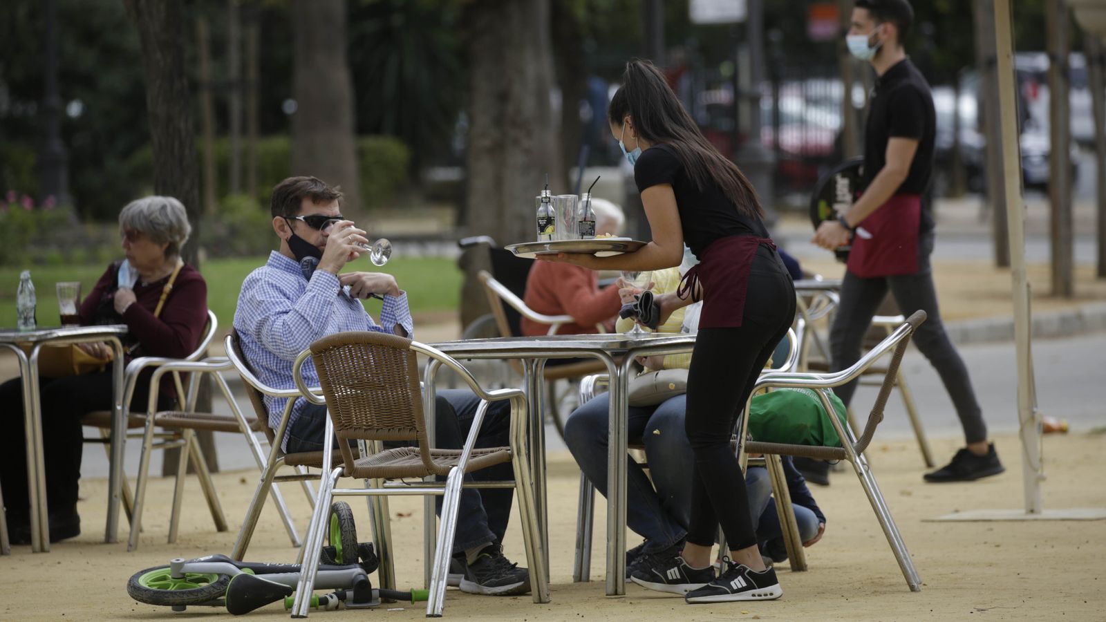 Clientes de un bar, en mesas separadas con más de dos metros.