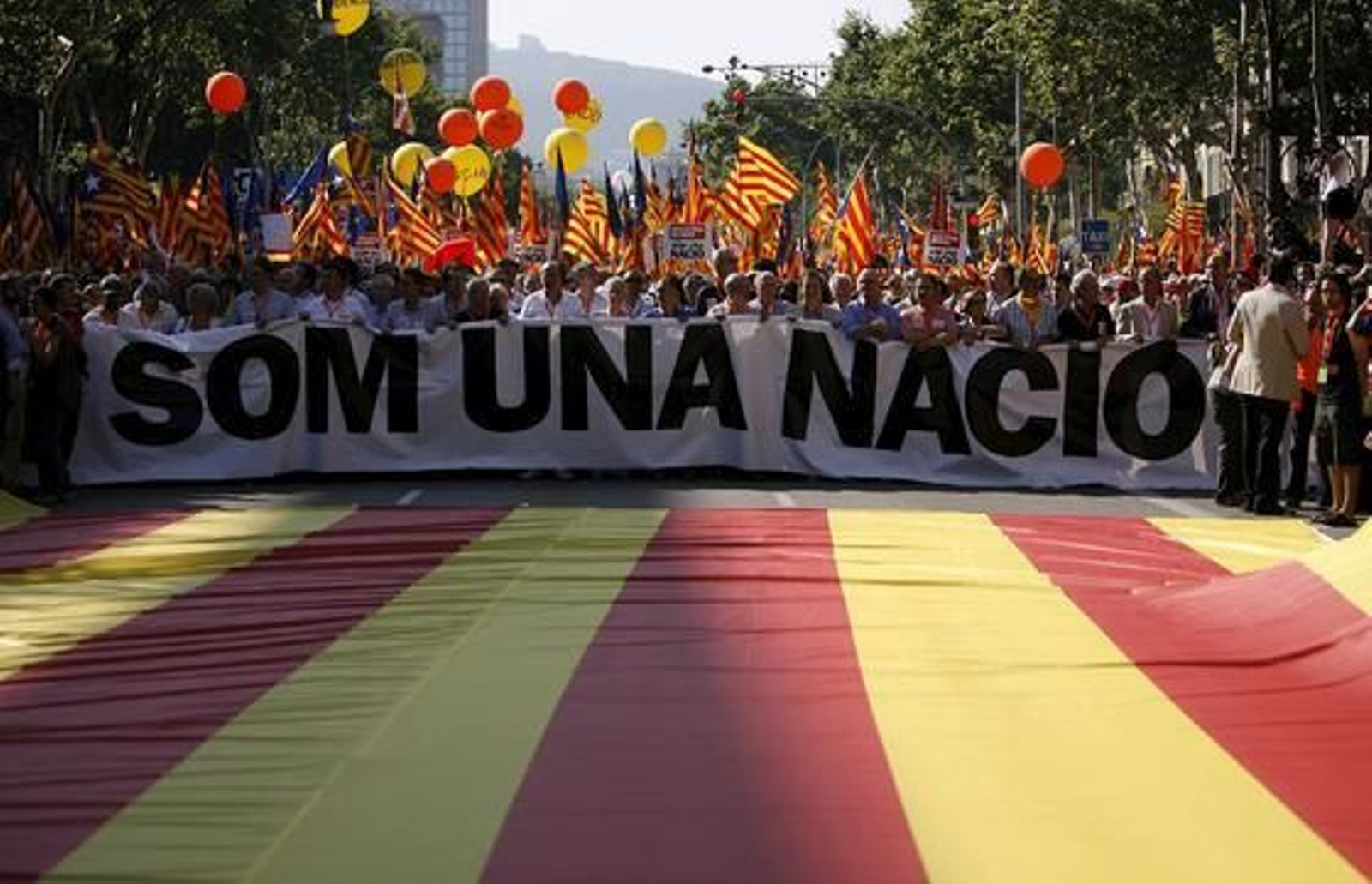 La cabecera de la manifestación con un cartel en el que se puede leer en catalán "Somos una nación". / EFE