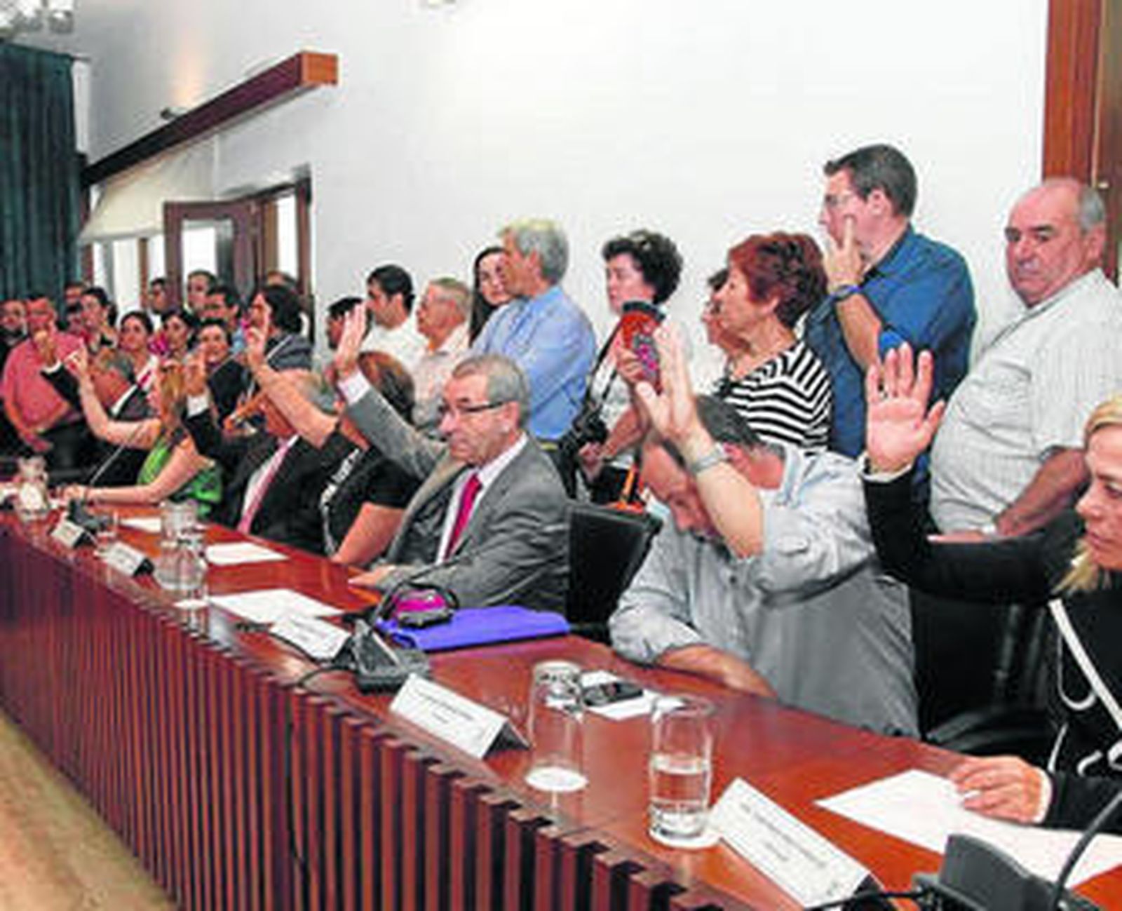 Carlos Pérez junto al nuevo alcalde, Juan Miguel Polo, con el bastón de mando sobre la mesa.