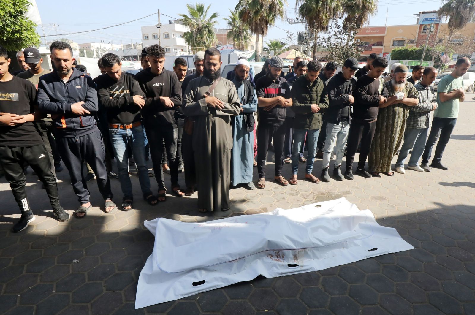 Palestinos rezan ante los cuerpos de familiares fallecidos.