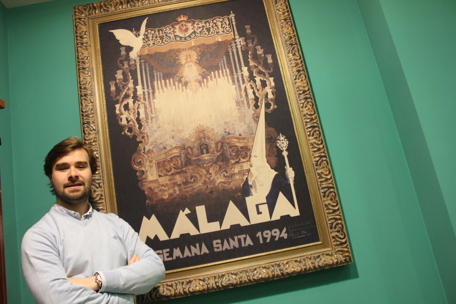 Antonio Centeno, ante el cartel de la Semana Santa de 1994 con el antiguo trono de la Paloma.