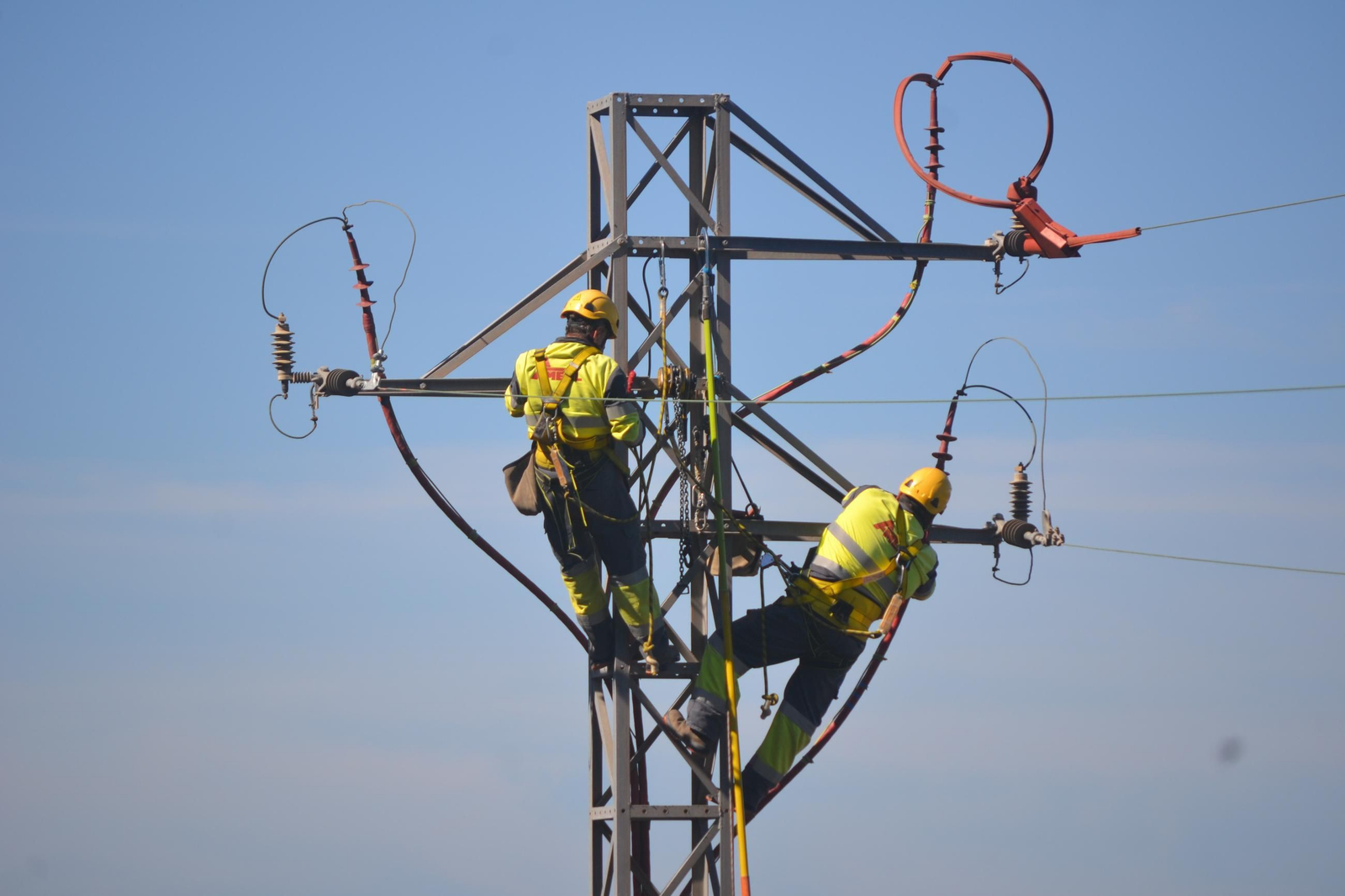 Imagen de archivo de trabajadores subidos a una torre de red de electricidad.