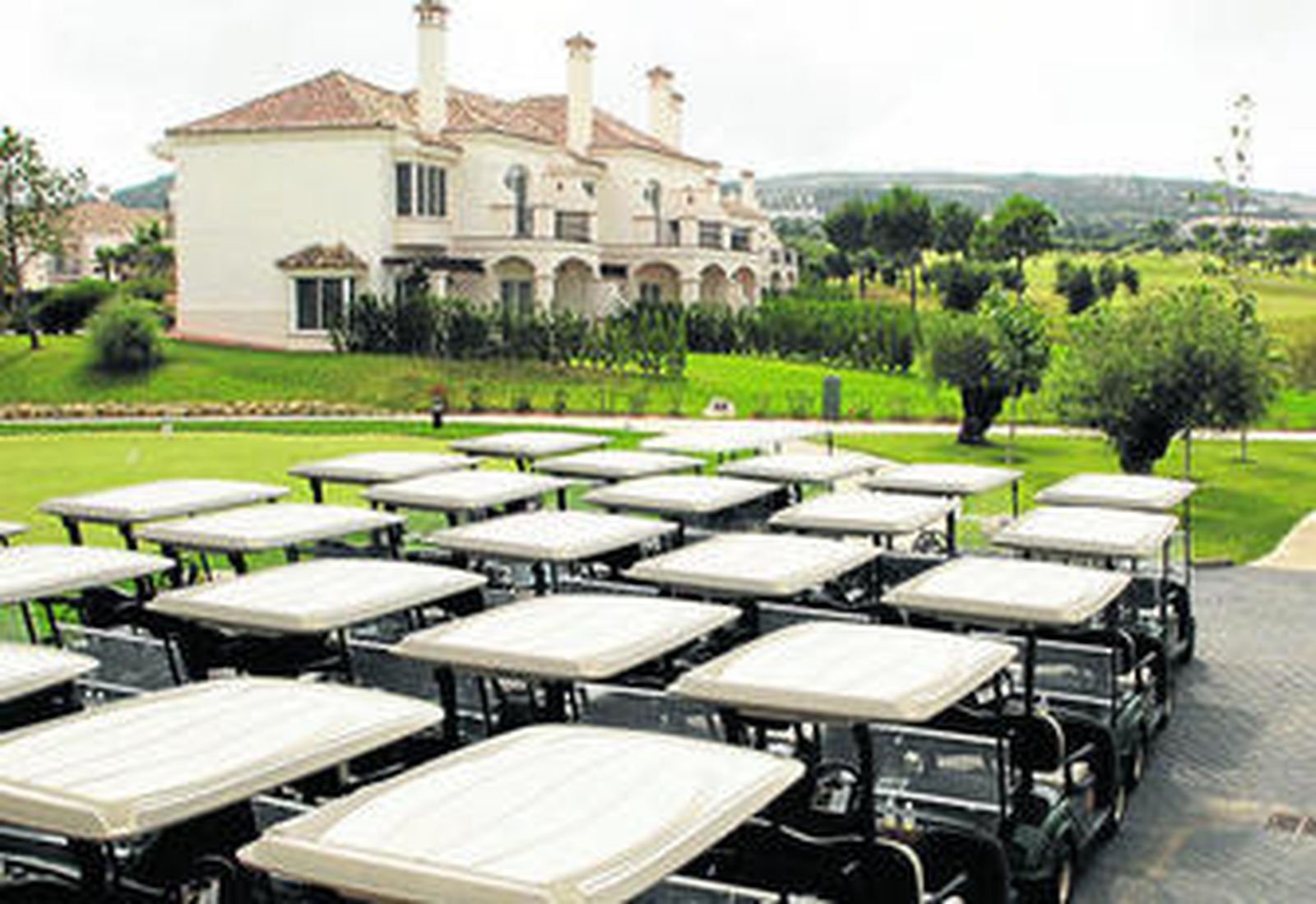 En primer término, los carritos para la práctica del golf en una zona cercana a la casa club.