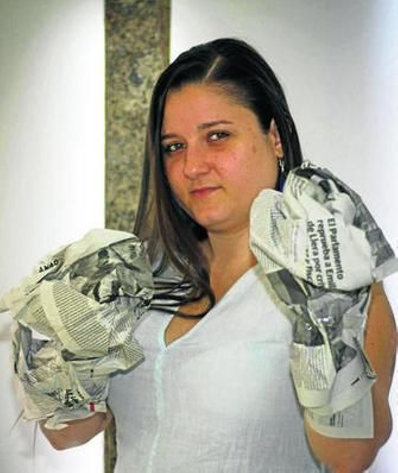 Paola Valverde, con dos guantes hechos con papel de periódico.