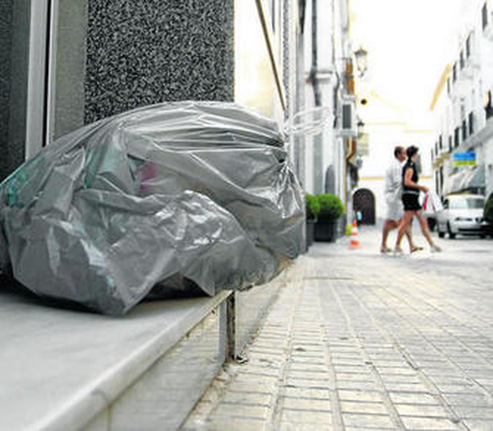 Una bolsa de basura en la puerta de un domicilio.