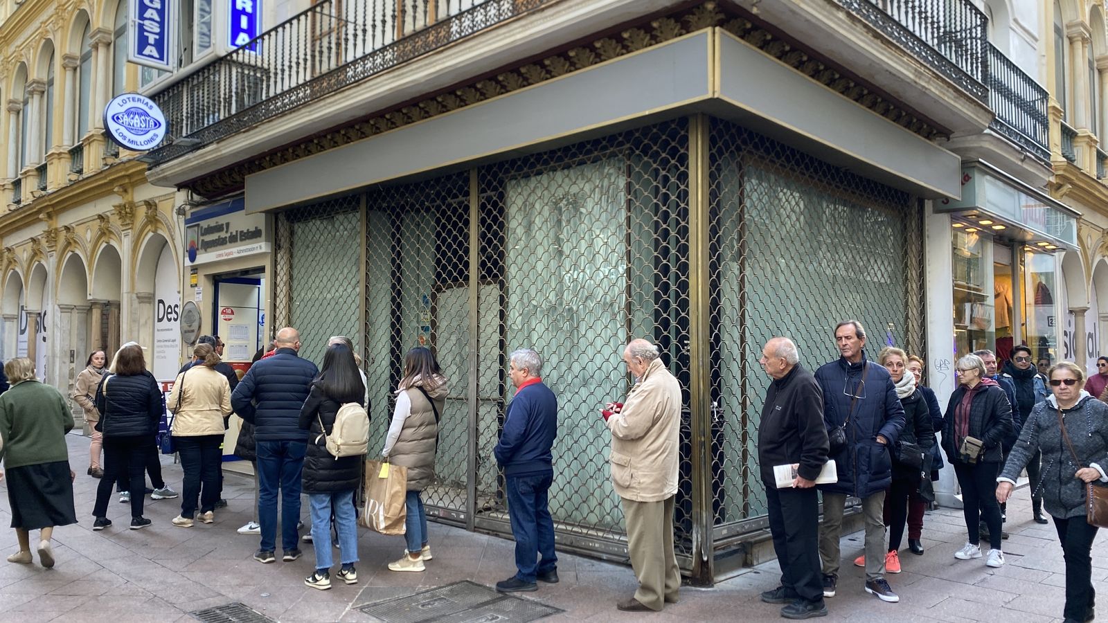 Personas hacen cola para comprar la lotería en calle Sagasta