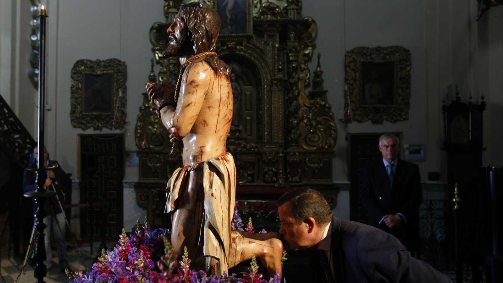 Un devoto besa el pie del Cristo de la Caridad