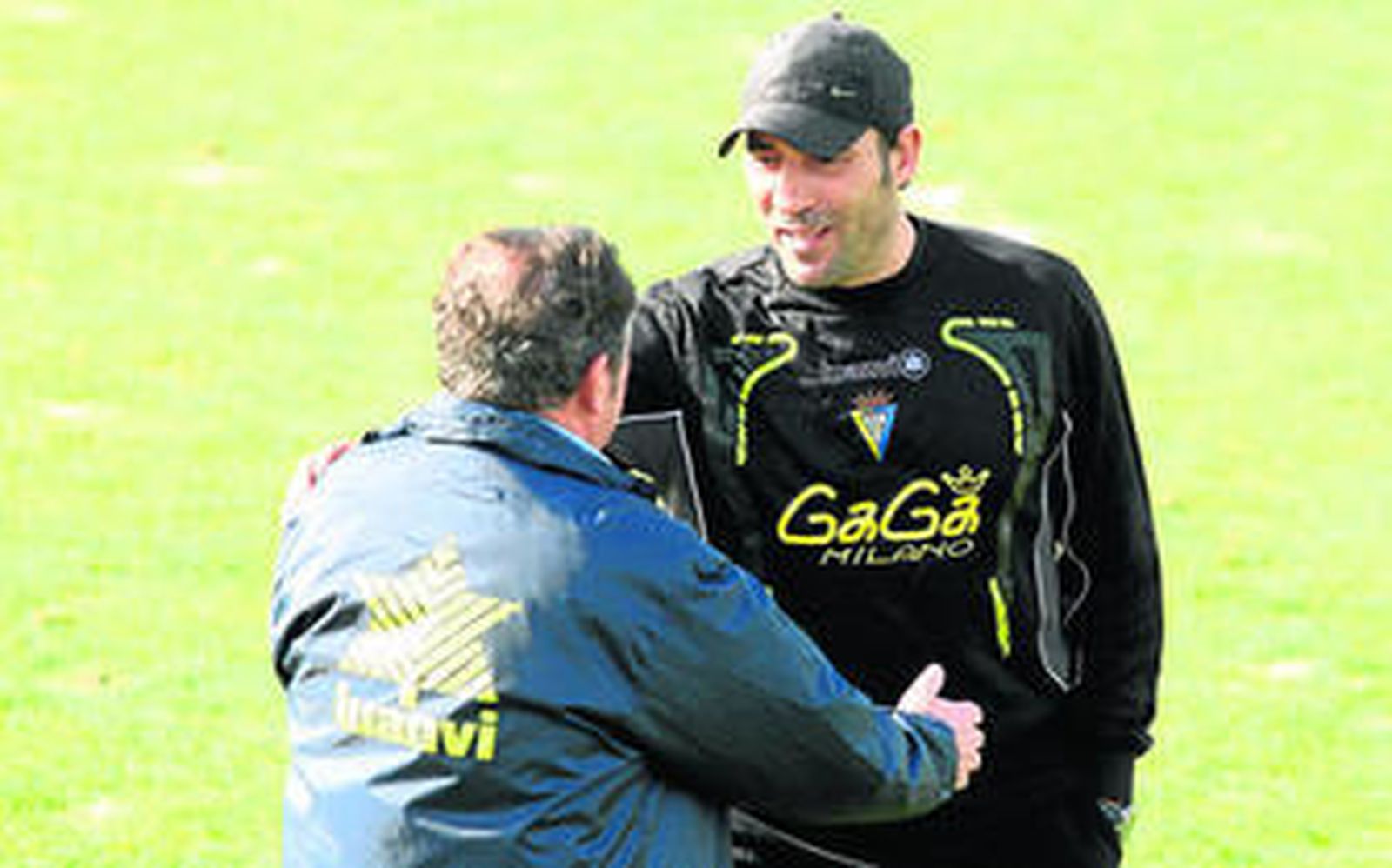 El jefe médico del club cadista, Martínez Villar (de espaldas), habla con Raúl Agné sobre el césped del campo principal de El Rosal.