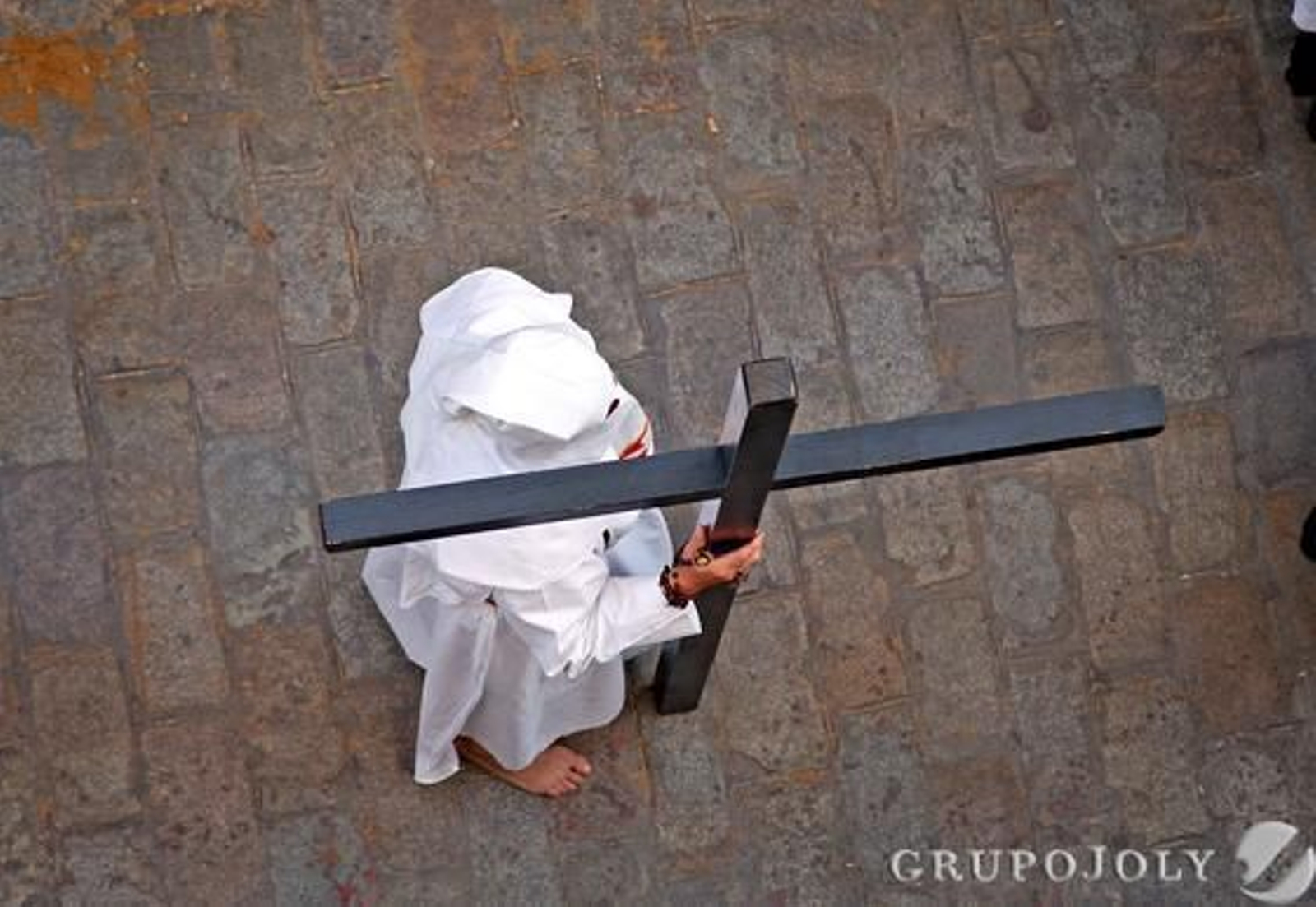 Un penitente del Santísimo Cristo del Amor descansa sobre la cruz con la que hace penitencia.

Foto: Vanesa Lobo