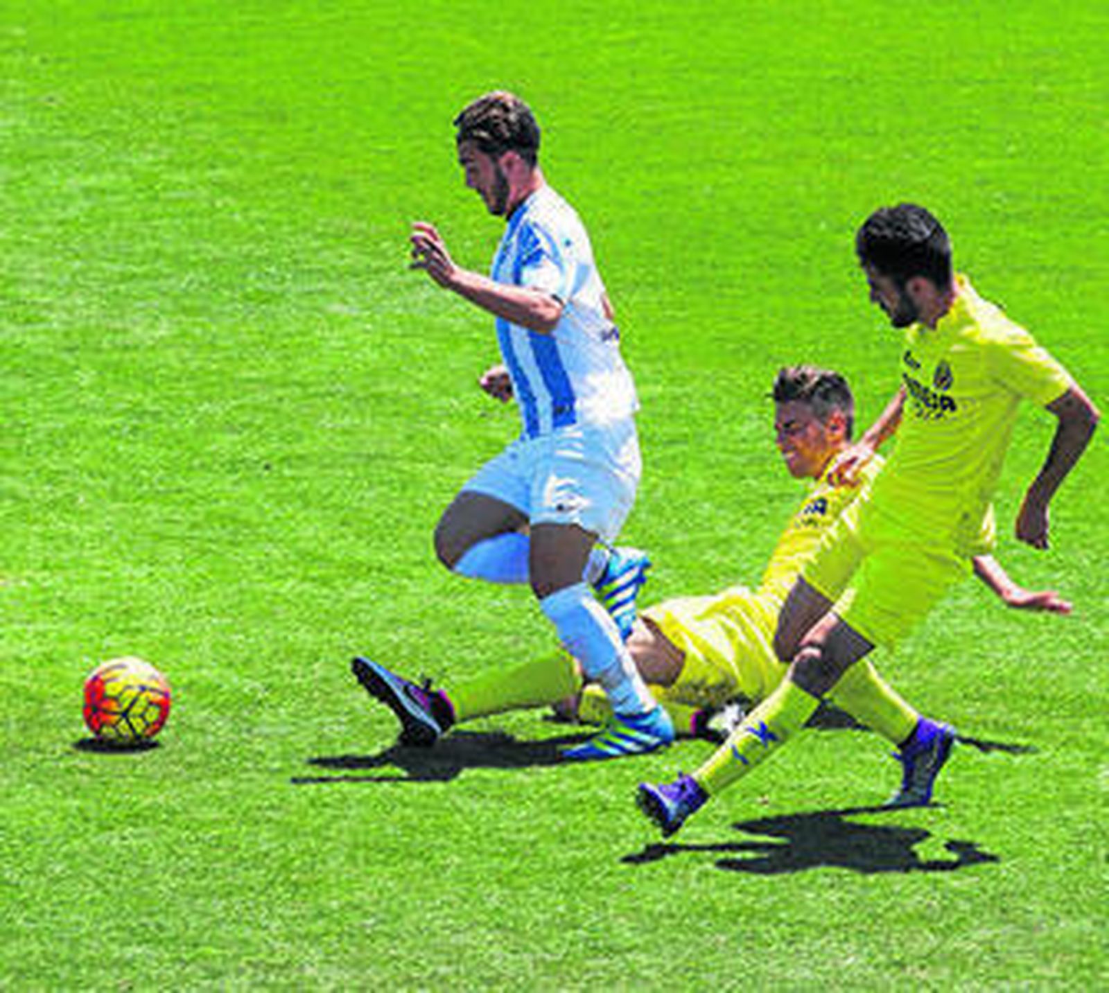 Un jugador del Málaga trata de zafarse de una entrada.