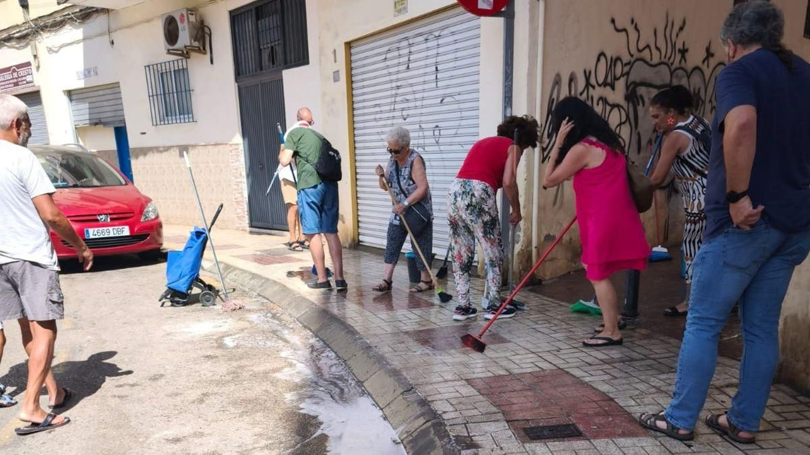 Vecinos limpiando la acera en el barrio de Miraflores