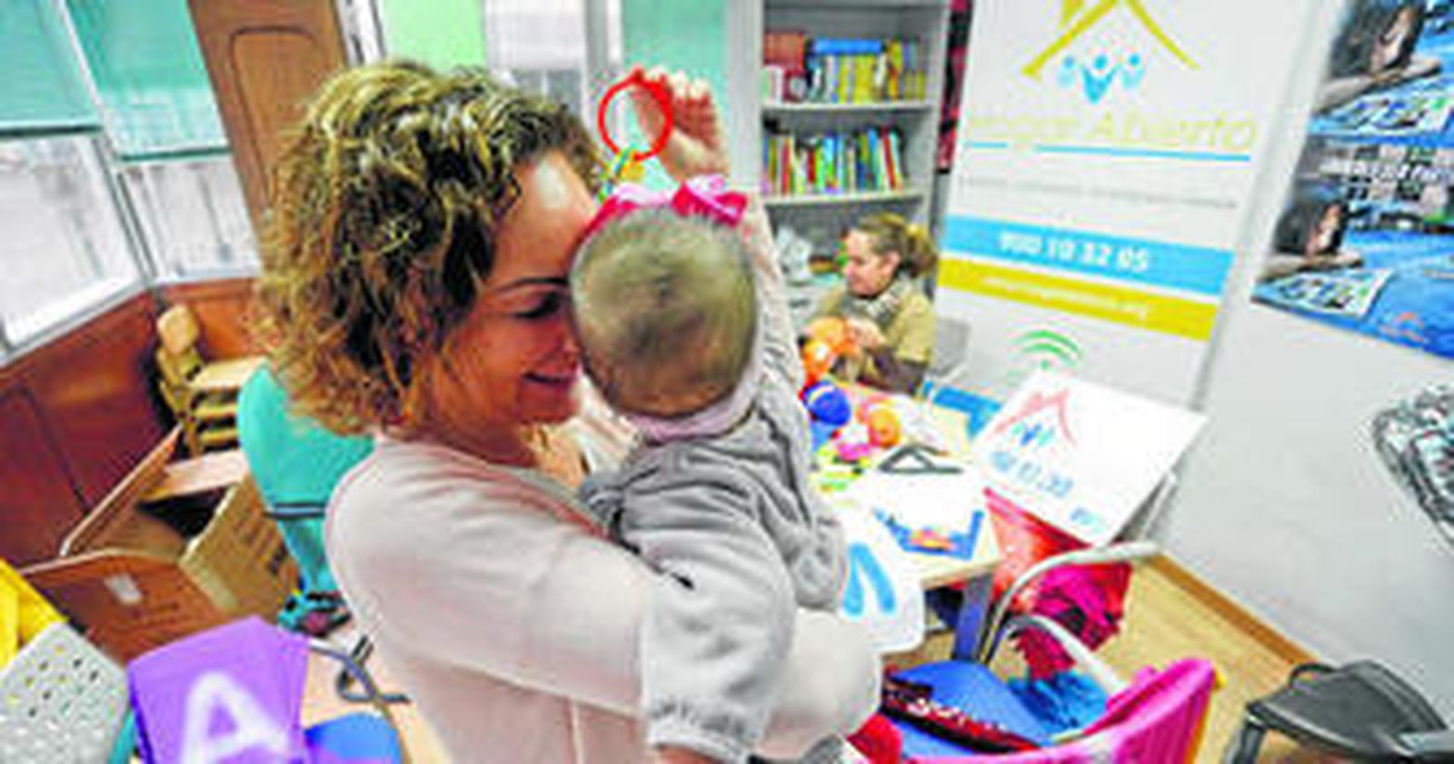 Una madre de acogida, Julia Cerdín, junto con un bebé en la preparación del material para el evento.