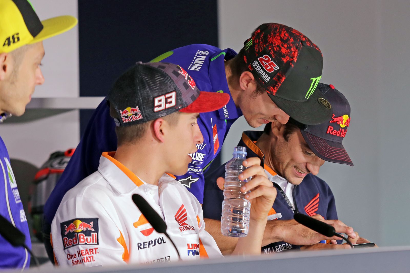 Viñales enseña algo a Pedrosa en su móvil junto a Marc Márquez.