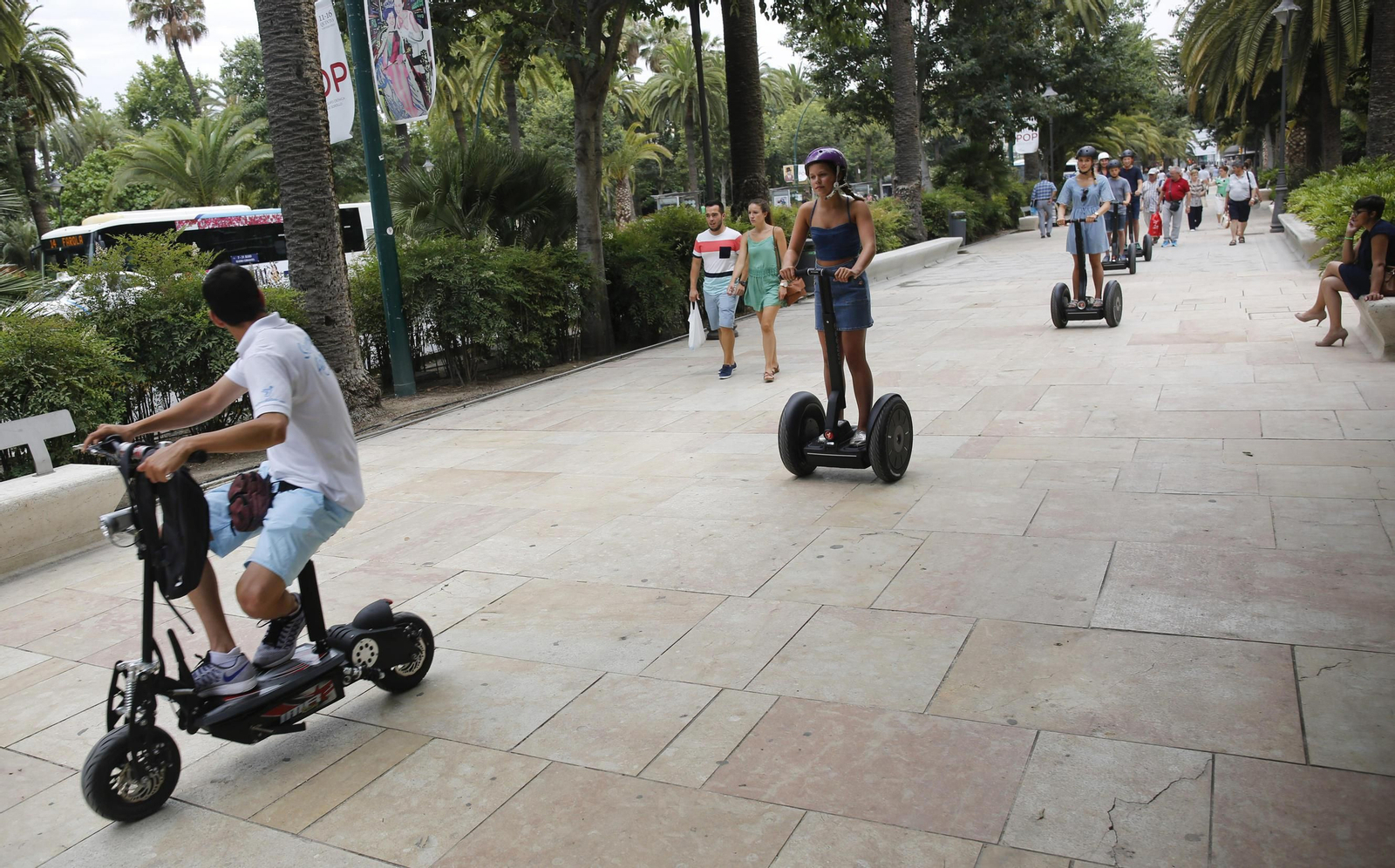 Varias personas circulan con un 'segway' por el Paseo del Parque.