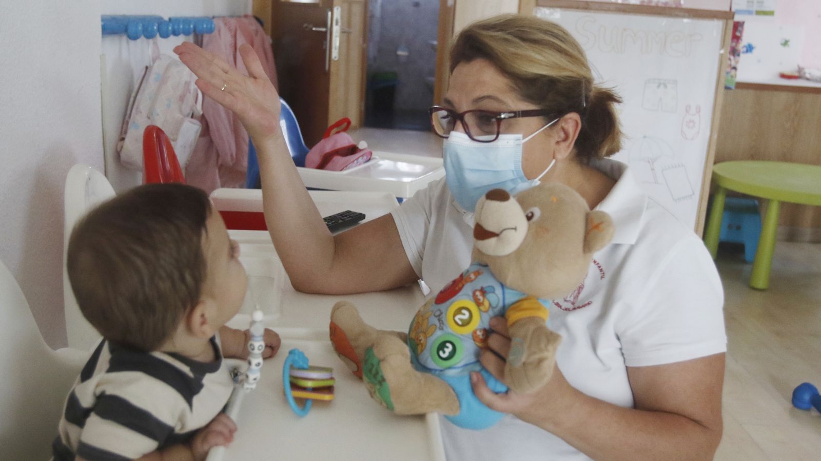 La docente de la escuela con uno de los alumnos más pequeños.