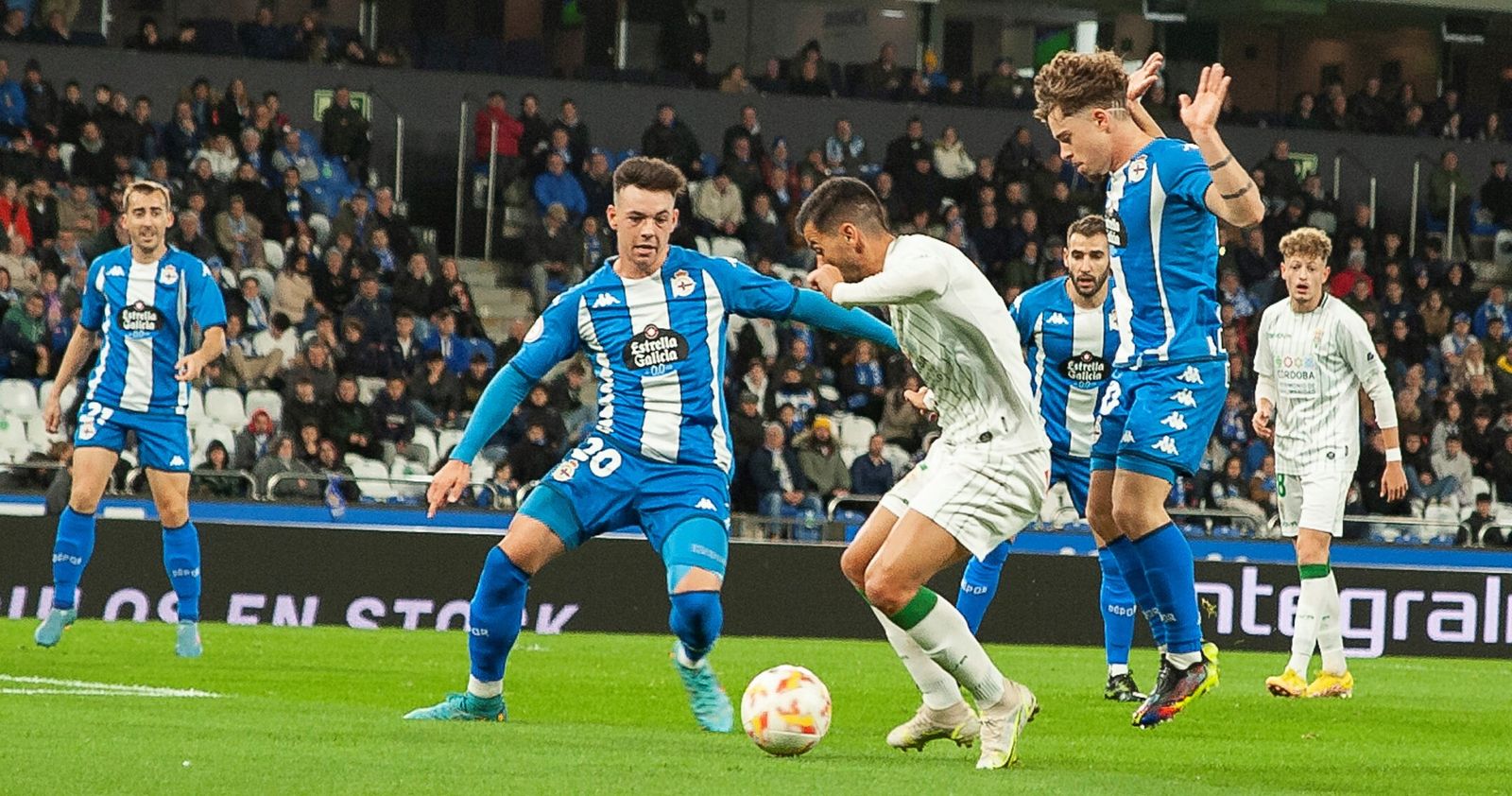 José Ruiz intenta el remate entre dos rivales en el Deportivo - Córdoba CF de la primera vuelta.