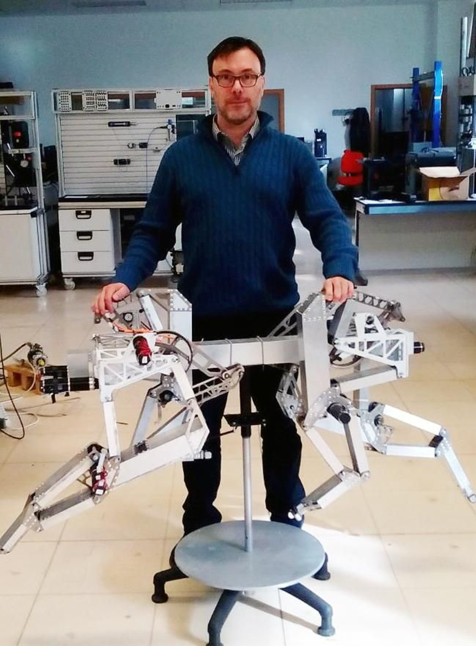 El investigador Antonio González junto a un prototipo de robot.