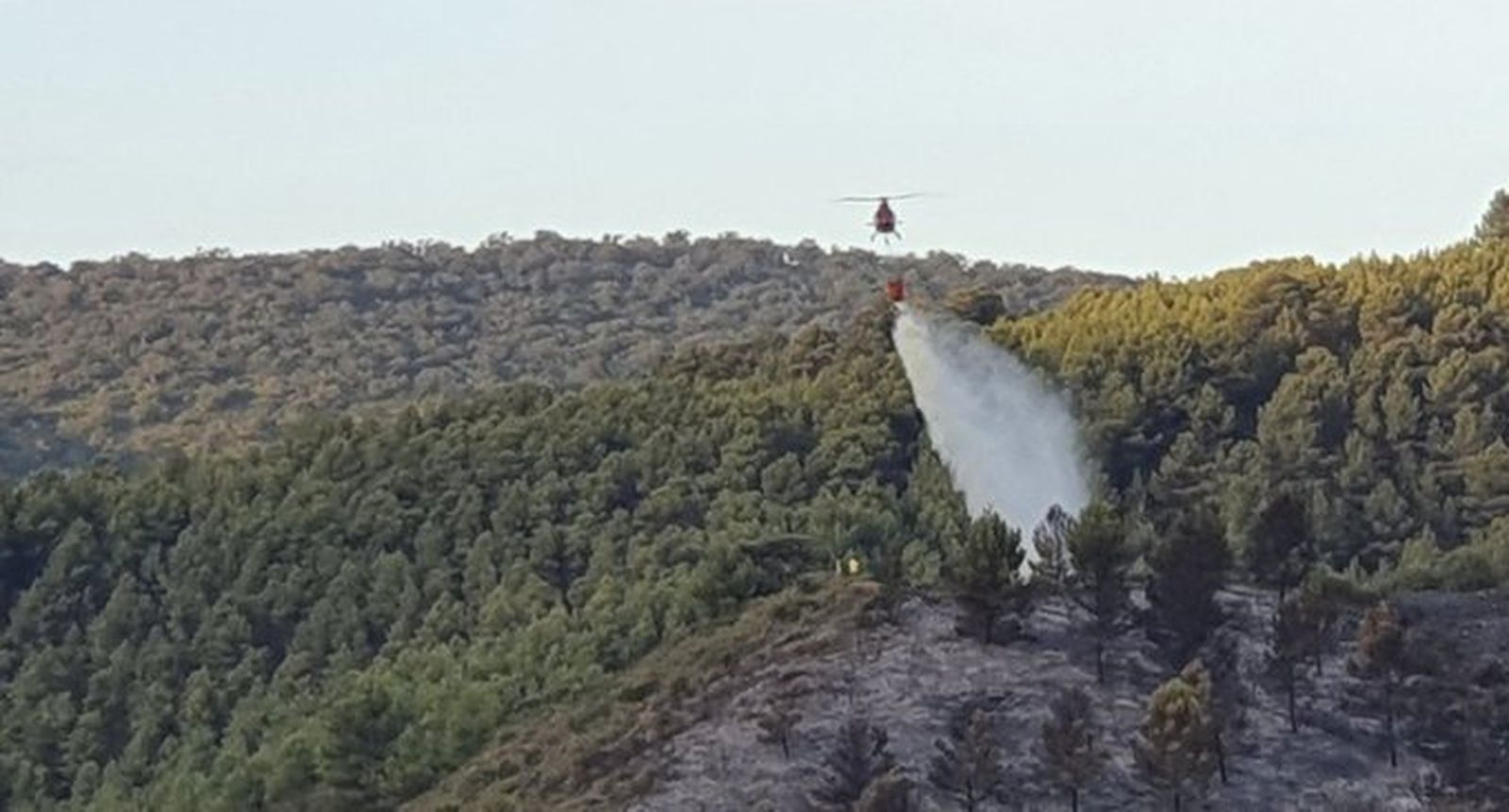 Uno de los helicópteros descargando agua en el interior del perímetro del incendio.