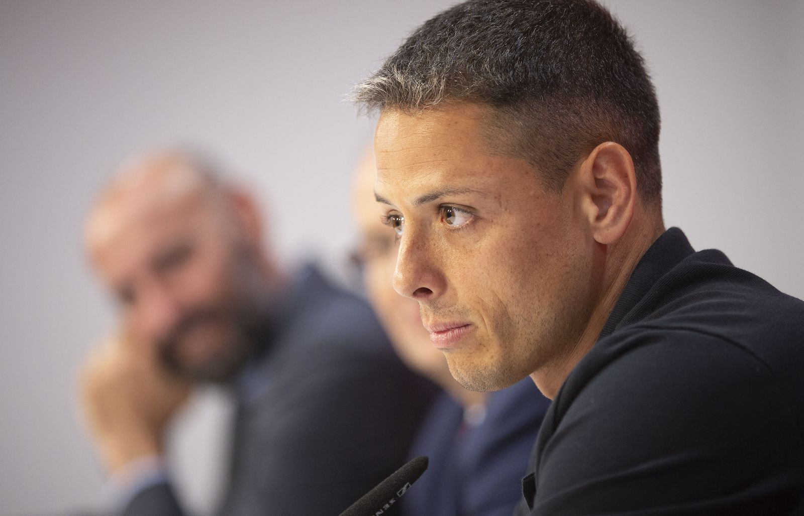 Chicharito, con Monchi difuminado al fondo, durante su presentación como jugador del Sevilla.