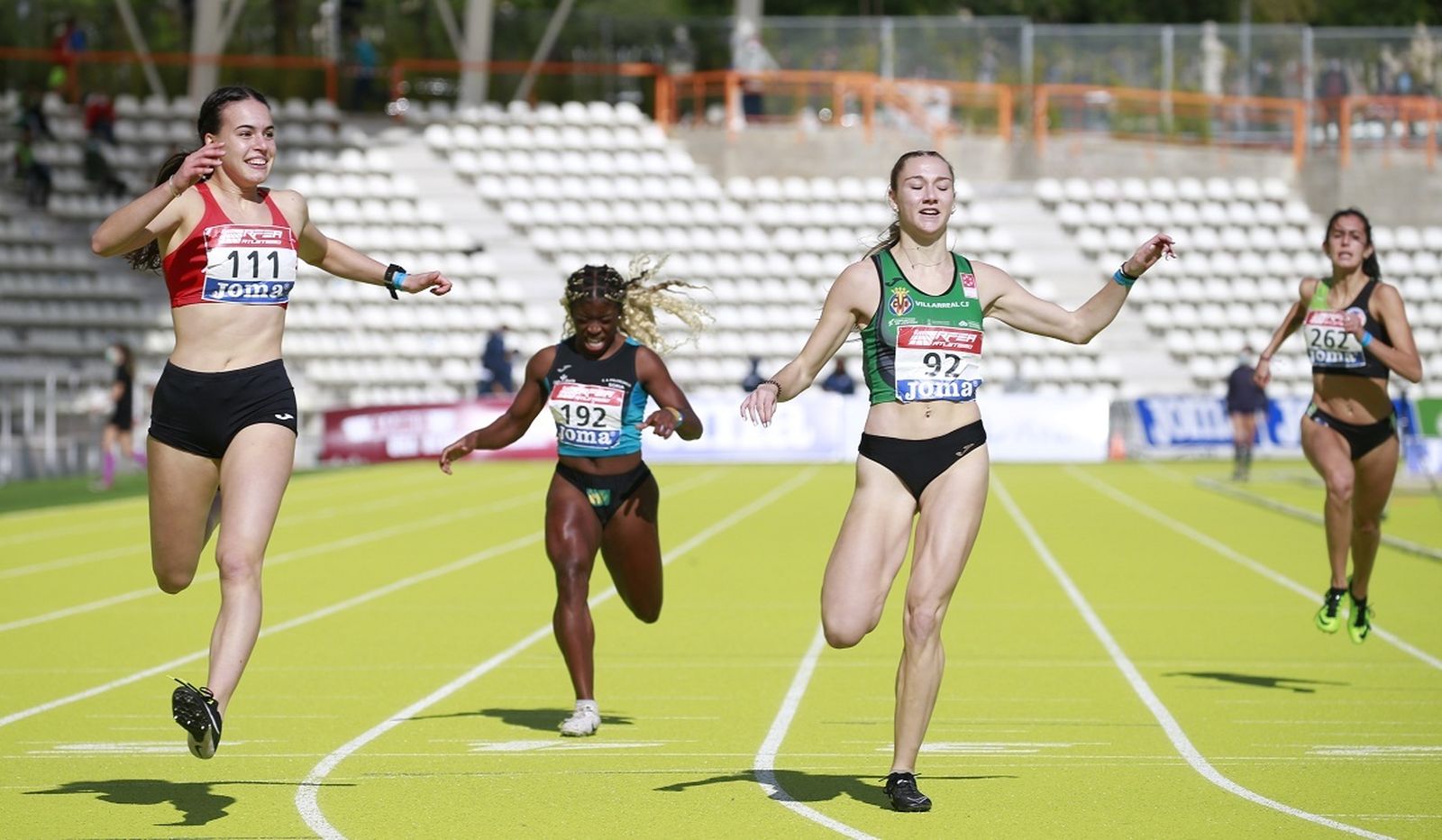 Carmen Avilés, a la izquierda, sonriente tras cruzar la línea de meta en la final de los 200 metros.