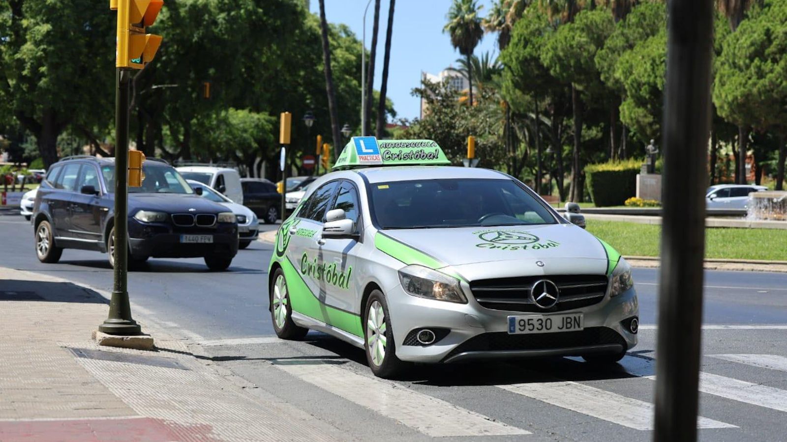 Un coche de autoescuela encara la Avenida de Andalucía.