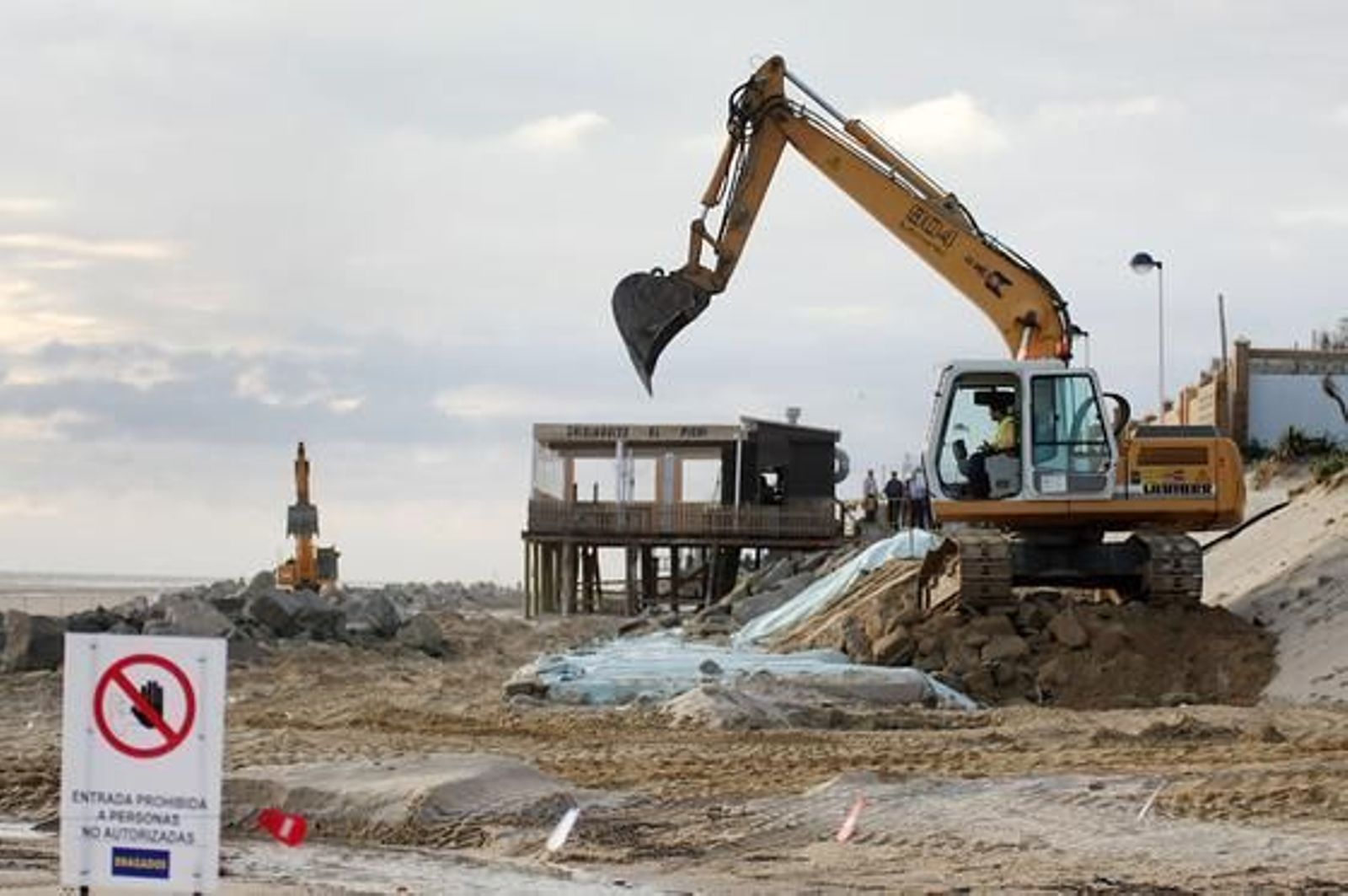 Una grúa opera a pie de playa. / Alberto Domínguez