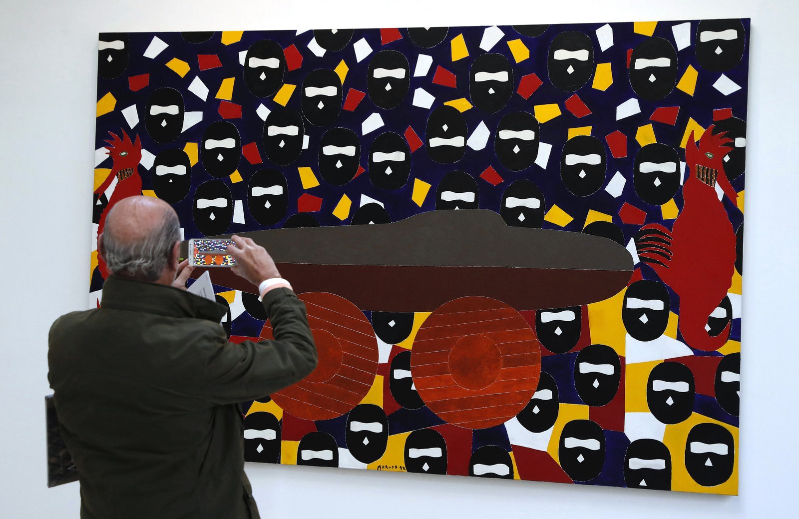 Un visitante fotografía este viernes en Madrid el lienzo de Eduardo Arroyo 'El buque fantasma'.