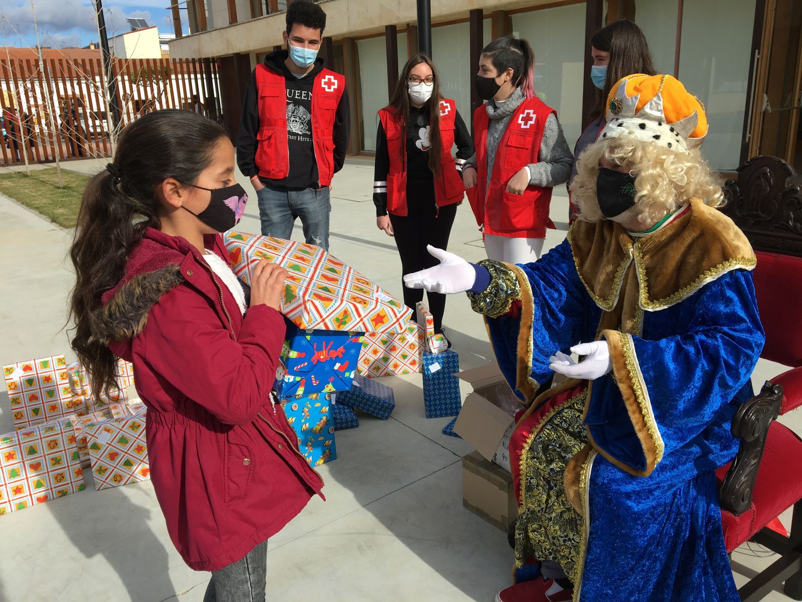 Uno de los menores recibe sus regalos de manos de Melchor