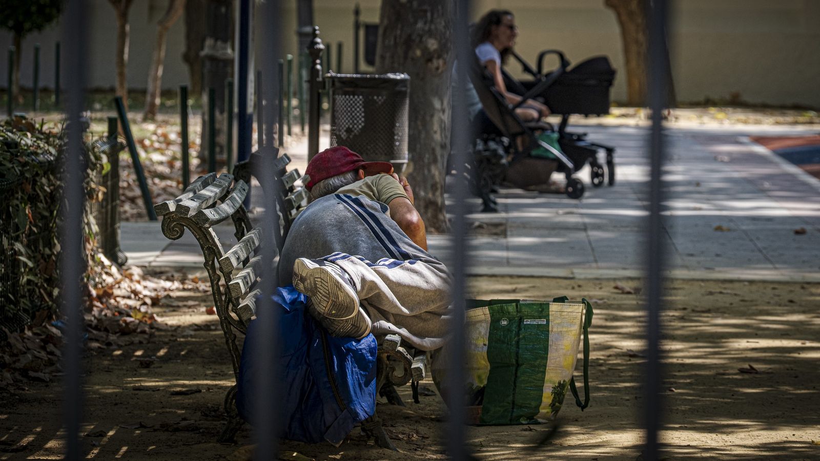 Imagen de archivo de una persona sin hogar durmiendo en un banco de un parque de Cádiz.