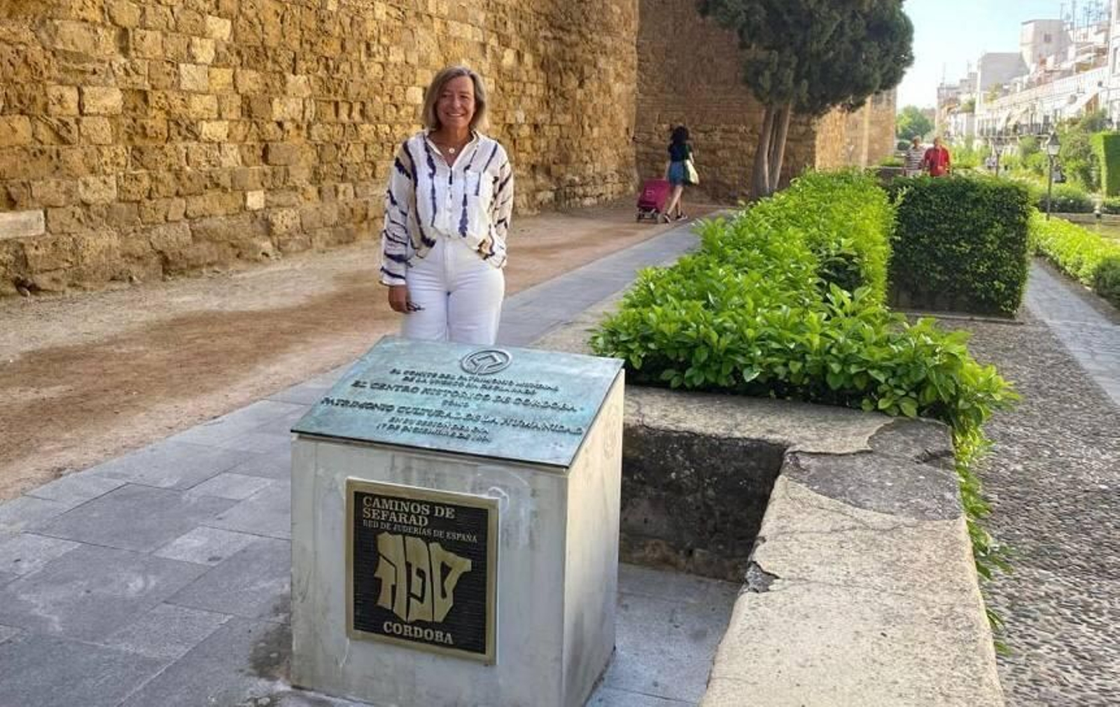 Isabel Albás junto a la placa conmemorativa.