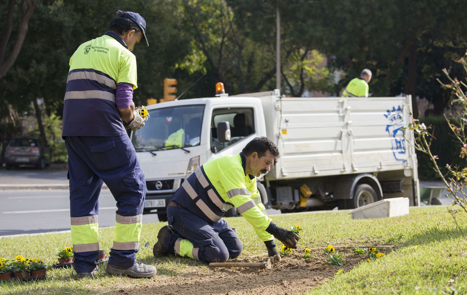 Dos trabajadores hacen labores de jardinería.