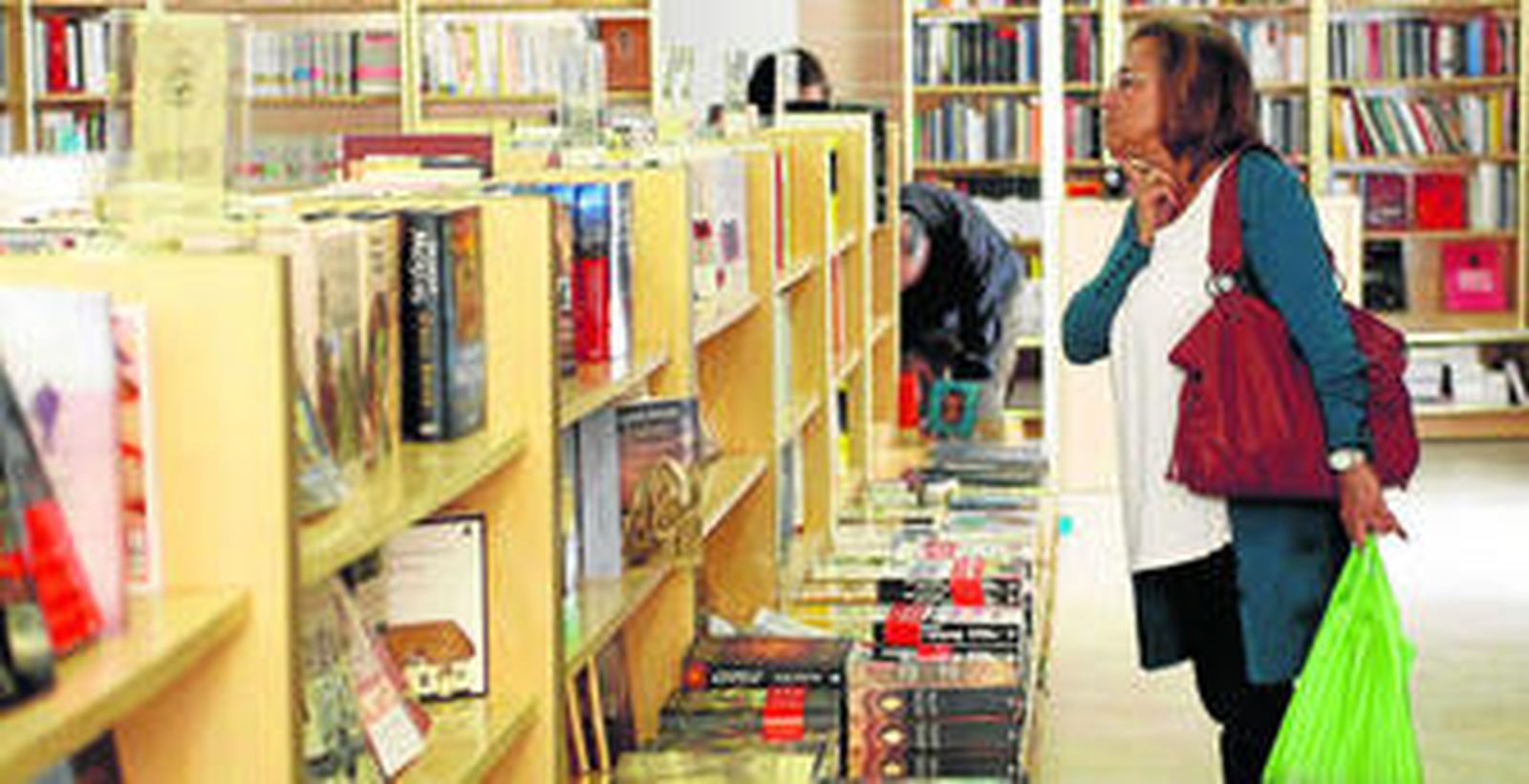 Una mujer consulta los títulos de una librería.