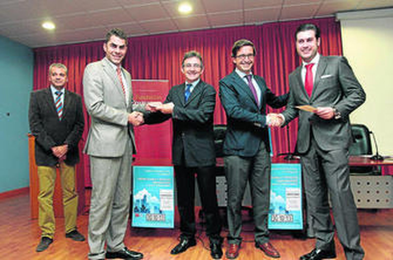 El rector de la UHU -izquierda- y el director de la Cátedra Cruzcampo entregan el premio.