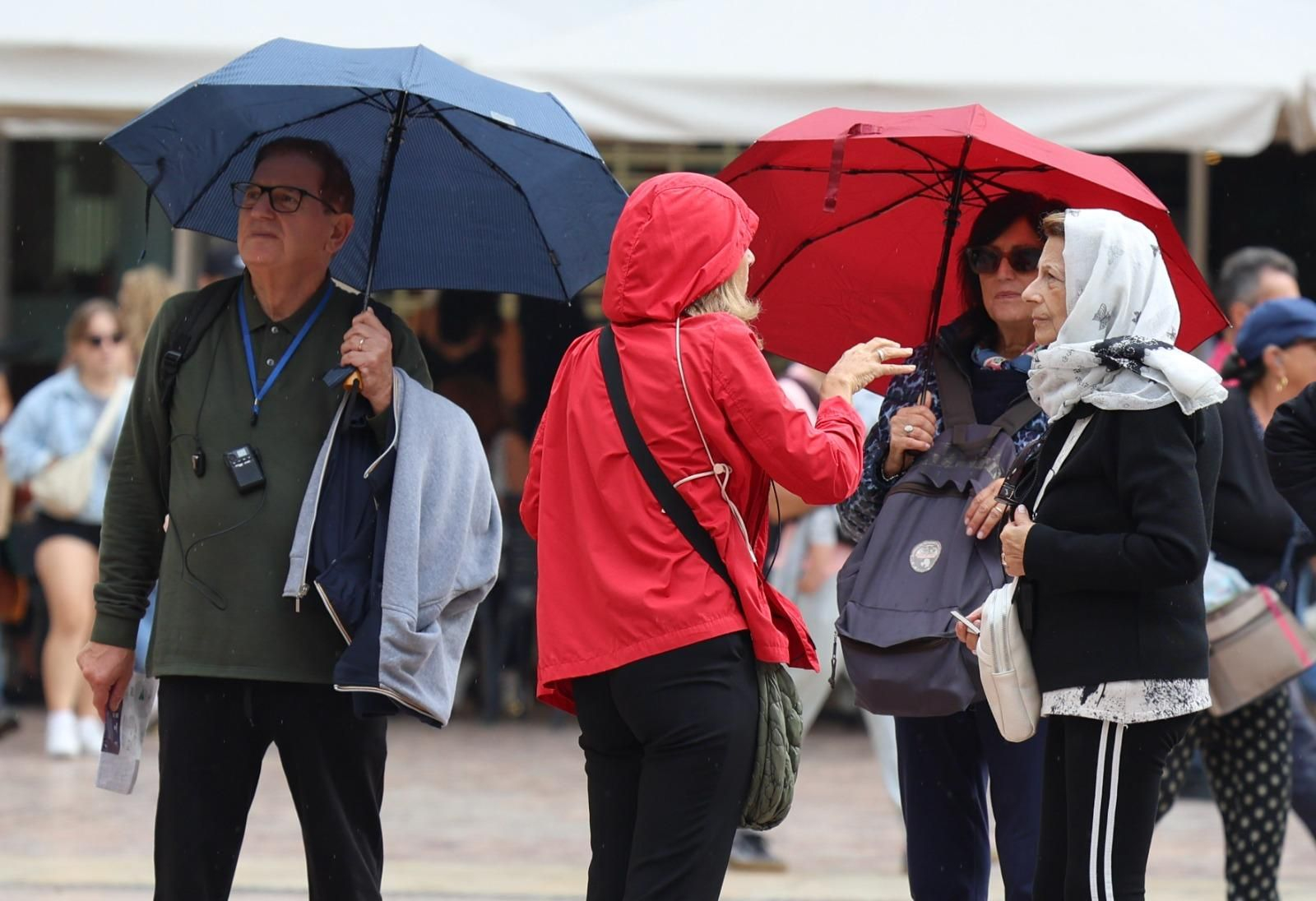 Un grupo se protege de la lluvia con paraguas y chubasqueros en el centro de Málaga. Un grupo se protege de la lluvia con paraguas y chubasqueros en el centro de Málaga.