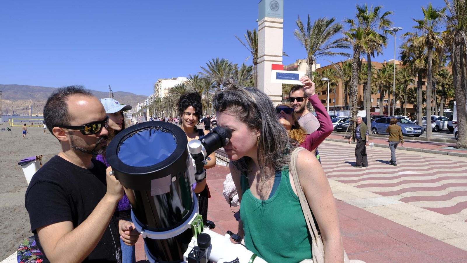 Almería observa el eclipse solar desde el Paseo Marítimo, en imágenes