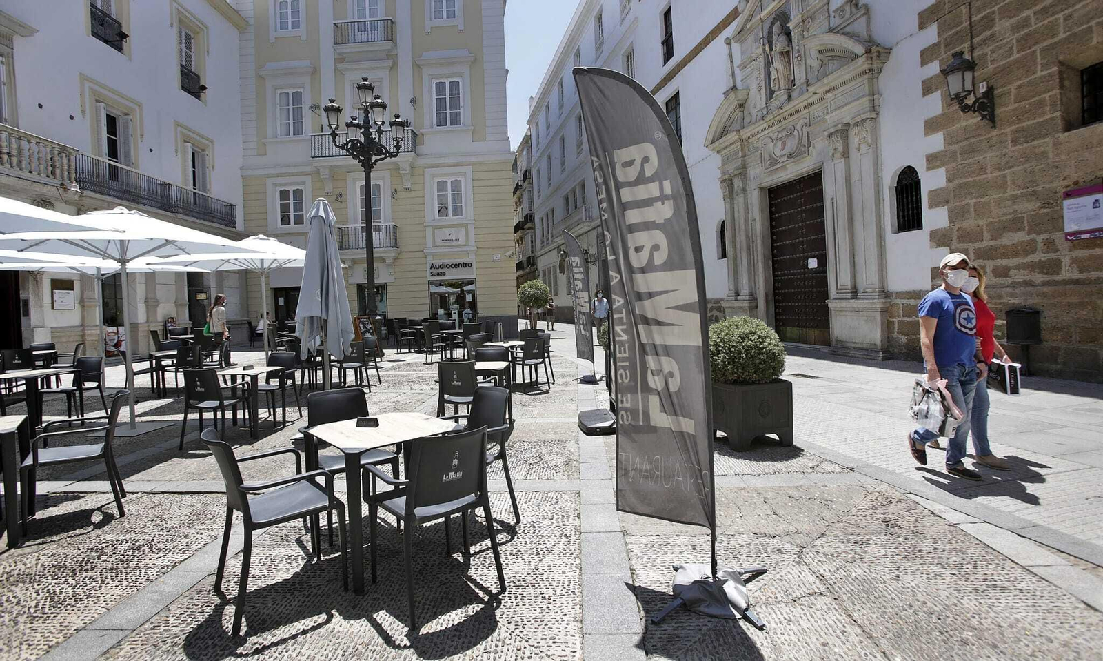 Varias personas pasean por el centro de Cádiz.