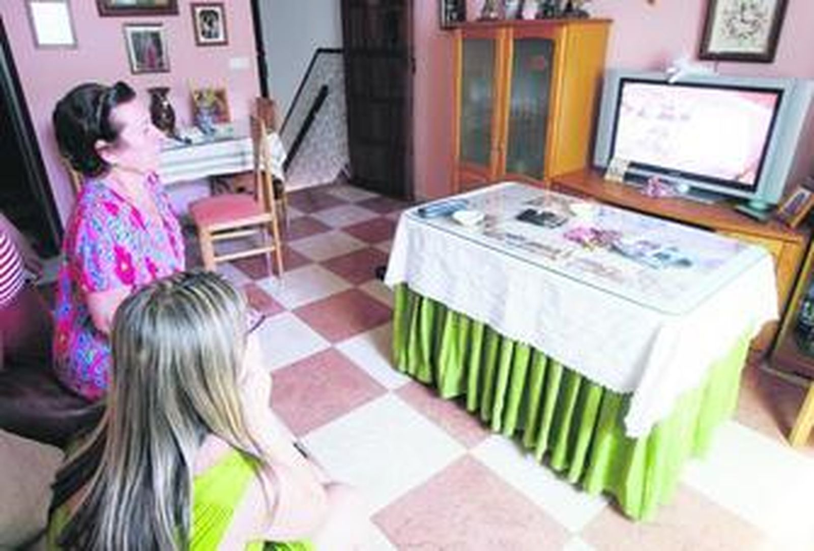 La madre y una hermana del detenido observan fotografías de Antonio por televisión, el miércoles.