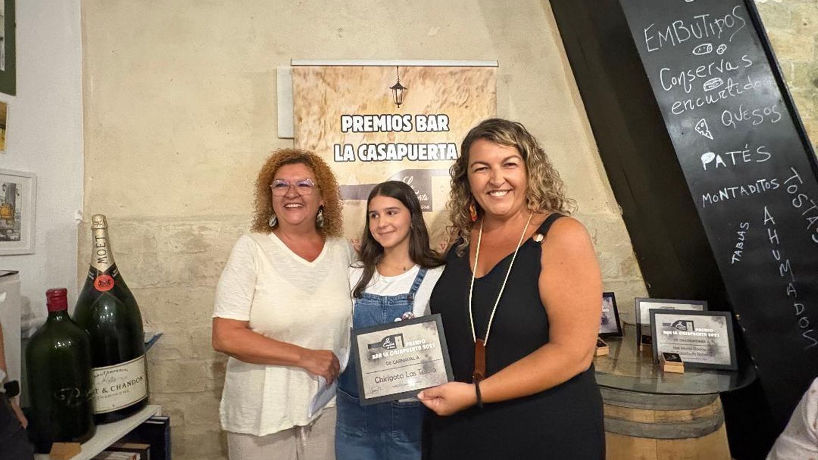Belén González Lozano entregando a Eva y Pilar Tubío el premio Bar La Casapuerta de Carnaval de la chirigota ‘Las Tubío’.