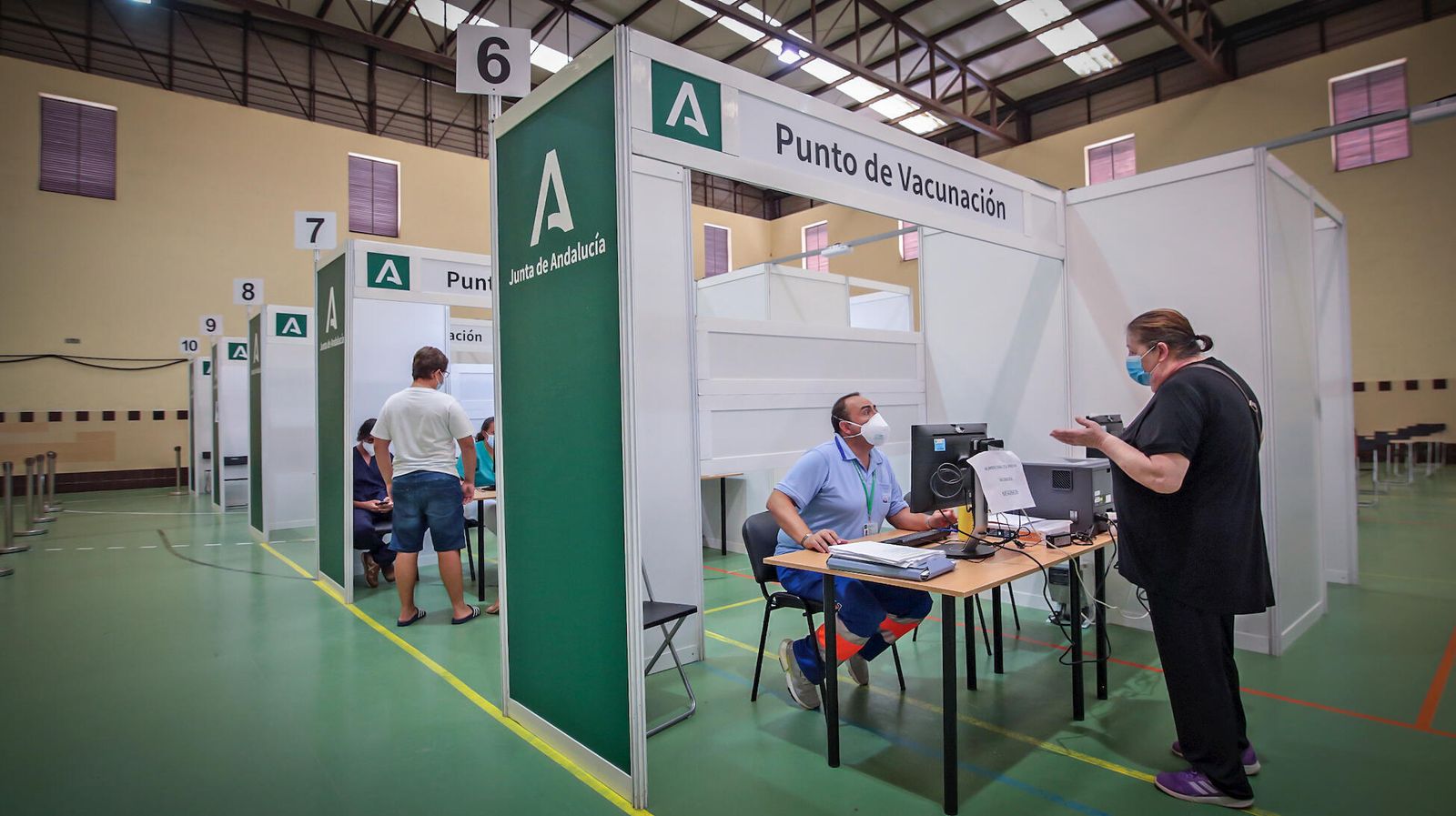 Un sanitario del dispositivo especial de vacunación en el Vega Veguita resolviendo unas dudas a una usuaria, este viernes.