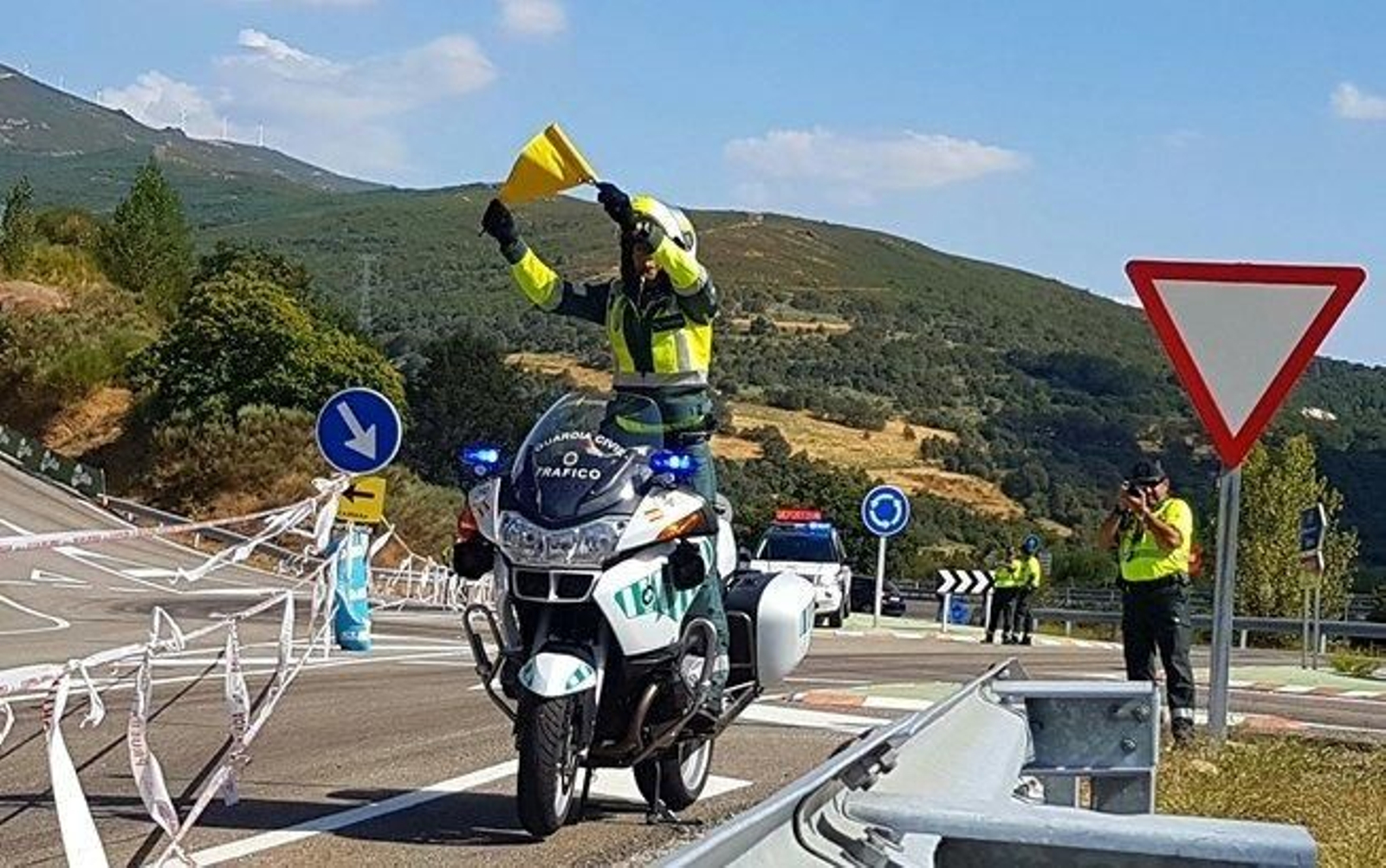 Un agente de la Guardia Civil muestra un banderín amarillo en la carretera