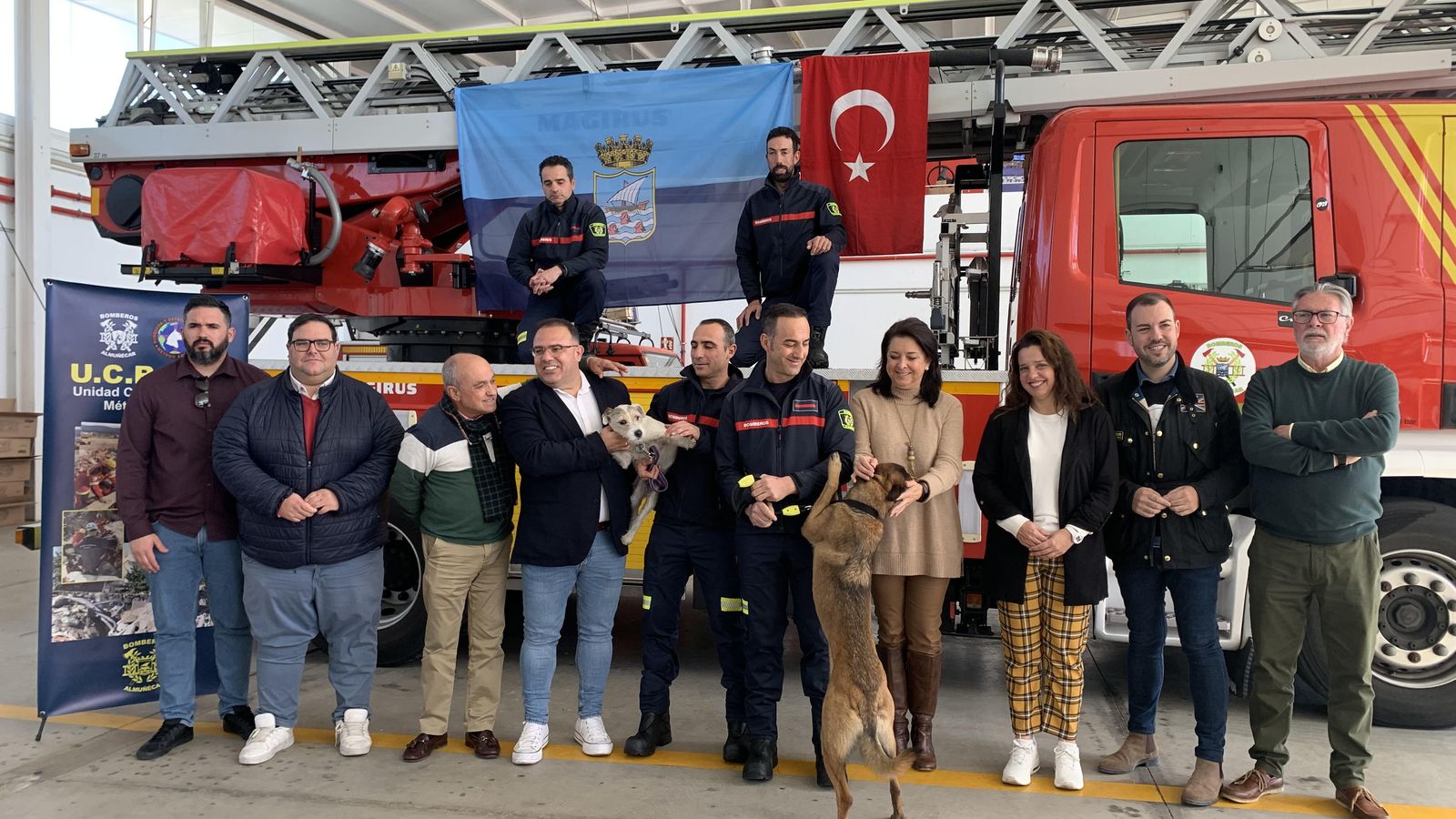 Los cuatro bomberos, junto a Zeus y Maya, y representantes del Ayuntamiento de Almuñécar
